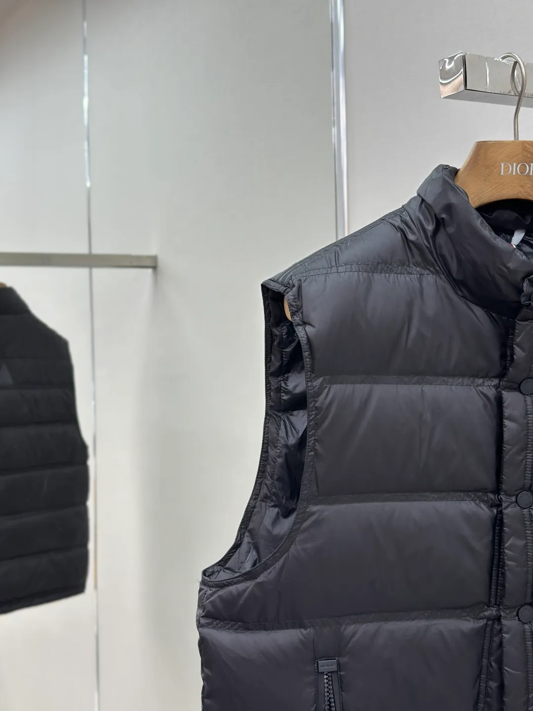 P680 MONCLER down vest with reflective markings Fabric selection: Made of ultra-fine nylon yarn woven in a high-density manner. The number of yarns per unit area is large, and the gaps between the yarns are very small, which can effectively block the penetration of cold wind. The fine weave keeps it lightweight and soft to the touch, physically restricting the lightweight down fibers from slipping through the gaps. Nylon fiber itself has good wear resistance and is not easy to snag, which significantly extends its service life and can easily cope with the needs of multiple scenarios.  Lining selection: The lining is made of 100% polyester fiber high-density weaving. The thickness of 0.08mm avoids increasing the overall weight and makes it smooth to wear. The high-density weaving structure forms a wind resistance layer to protect the thermal efficiency of the thermal insulation layer from loss. At the same time, it can withstand the expansion pressure of down and prevent deformation and damage after long-term use.  High-quality filling: 90 white duck down is selected, with a weight of 130g, ensuring excellent thermal insulation performance. After strict screening and processing, the velvet is not easy to get drilled, ensuring durability.  Process: Through the reflective cloth punching process, the logo is regularly arranged on the triangular reflective mark with dozens of small holes, which not only improves the functionality, but also strengthens the recognition and aesthetics.   Accessories: Customized snap buttons, customized zipper pullers, customized badges, customized elastic buckles, etc. SIZE: 1 2 3 4