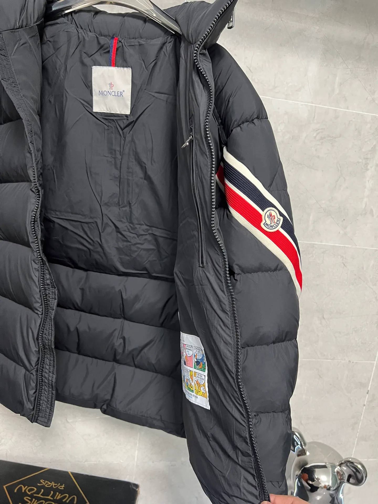 P880 MonclerSolayan men's short down jacket is decorated with seasonal iconic stripe details, blending sportsmanship and timeless style. Solayan down is made of micro chic fabrics and has a tough square shape design, highlighting Moncler's sportsmanship. This cropped style features tricolor stripes on the sleeves for a seasonal interpretation of the brand's signature. Comes with a practical pull-out hood. Color: Black Dark Brown Size: 12345
