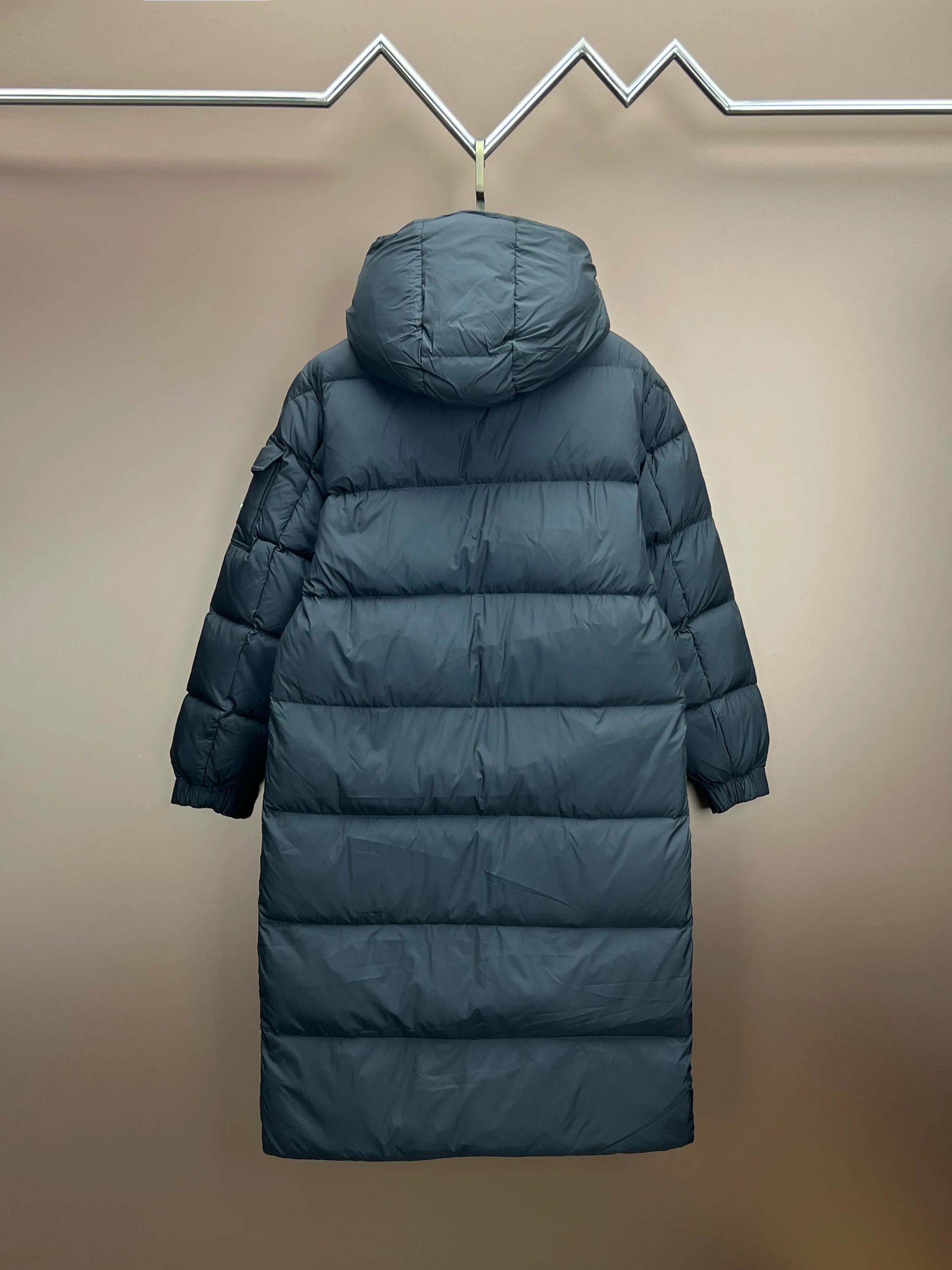 P920 Moncler Hanoverian line (matte matte) long men's. 850+ fill power, this Hanoverian men's long down combines Moncler's classic aesthetics, excellent performance and protective features. Hanoverian long down is made of longue saison fabric and is designed with practical details to provide both warmth and protection. As a Moncler classic, this model features a detachable hood and a front zipper placket that covers the windshield, significantly improving its protective performance. Details Made of longue saison fabric Longue saison lining Filled with down Removable hood Zipper and snap fastening Zippered pockets Patch pockets on sleeves Adjustable cuffs Drawstring hem Size: 0-4 (couple size)