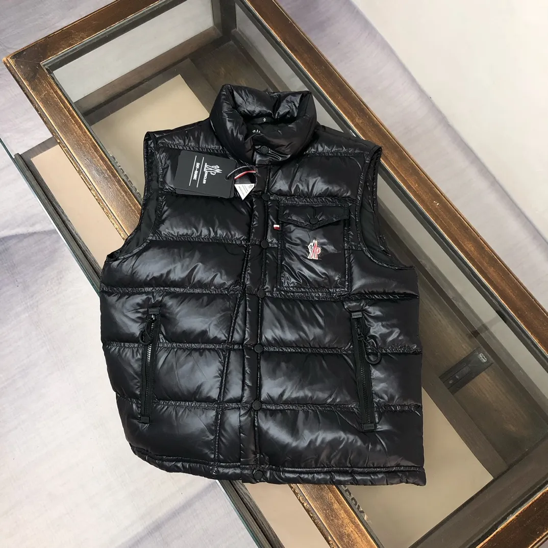 P760 Moncler Men's 2025 Autumn and Winter New Nantu Ski Series Men's Stand Collar Down Vest Vest. Wear it both outside and inside. Unlock the full-scene dressing formula and refuse to be bulky. It requires warmth and style! The Nantu ski series vest is a masterstroke for layering in winter. The stand-up collar is designed to be windproof and can be paired with a sweater or sweatshirt to instantly enhance the sense of layering and give it a sporty and casual look. Inner layer: light and close-fitting, seamlessly integrated into the interior of a suit or coat, providing invisible warmth without looking bulky, and can easily cope with the temperature difference between indoors and outdoors. Designed from the professional ski line, its thermal insulation performance is unquestionable, and it can handle urban outdoor use with ease. The neat three-dimensional tailoring abandons the bulging feeling of traditional vests, and the side lines are clean and neat, creating a tall and straight figure. Color: Black Size: 0-1-2-3 (M-2XL)▪️