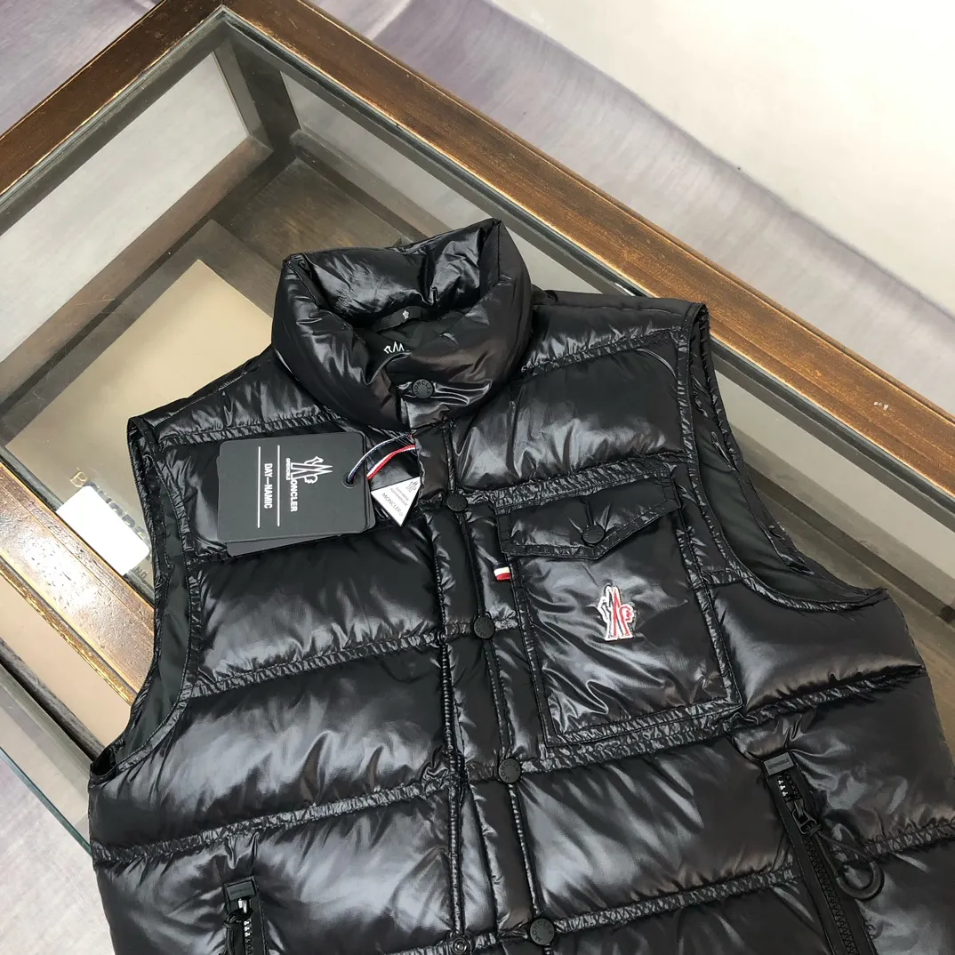 P760 Moncler Men's 2025 Autumn and Winter New Nantu Ski Series Men's Stand Collar Down Vest Vest. Wear it both outside and inside. Unlock the full-scene dressing formula and refuse to be bulky. It requires warmth and style! The Nantu ski series vest is a masterstroke for layering in winter. The stand-up collar is designed to be windproof and can be paired with a sweater or sweatshirt to instantly enhance the sense of layering and give it a sporty and casual look. Inner layer: light and close-fitting, seamlessly integrated into the interior of a suit or coat, providing invisible warmth without looking bulky, and can easily cope with the temperature difference between indoors and outdoors. Designed from the professional ski line, its thermal insulation performance is unquestionable, and it can handle urban outdoor use with ease. The neat three-dimensional tailoring abandons the bulging feeling of traditional vests, and the side lines are clean and neat, creating a tall and straight figure. Color: Black Size: 0-1-2-3 (M-2XL)▪️
