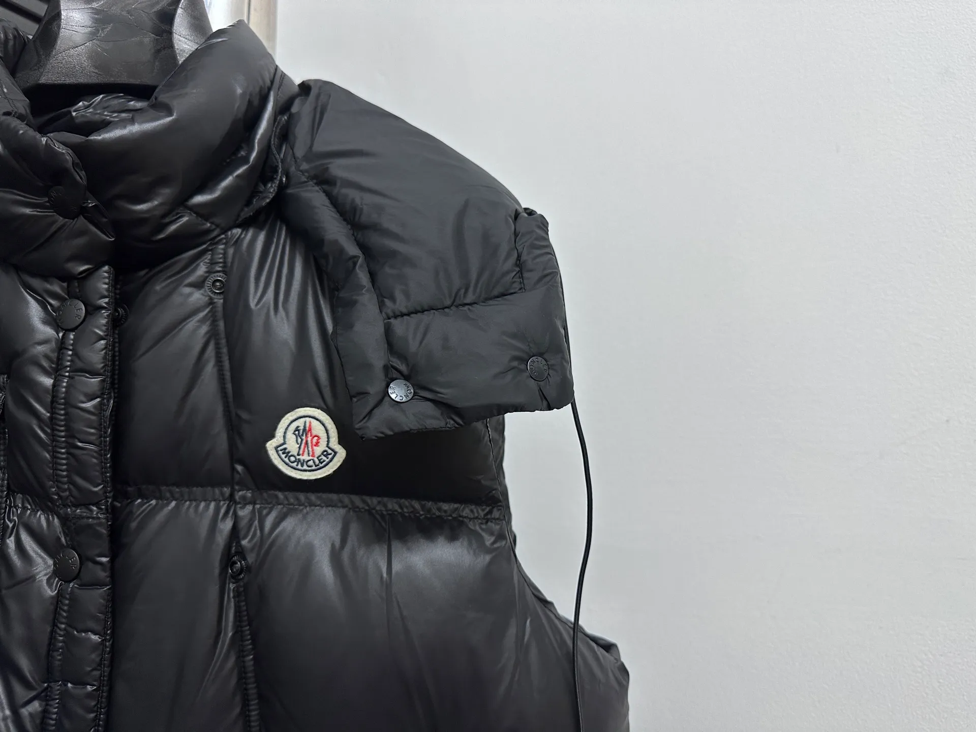 P740 [Moncler] Moncler's new autumn and winter product Pario women's hooded down vest. The Pario down vest cleverly uses shape and texture to show modern style. Made from functional super laque nylon fabric with a glossy finish. This hooded insulated piece features a double-snap closure for an asymmetrical shape. Trimmed with quilting in different sizes for a geometric feel. Size: 1-4 Color: Black Cream Mint Green