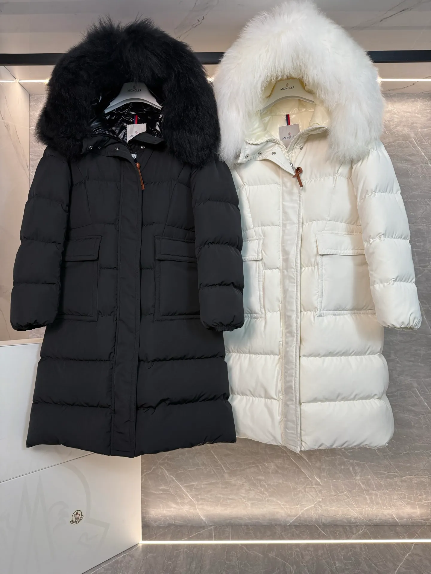P1180 ~ New in down ⬆️Moncler* mid-length women's hooded long down jacket. The long down jacket combines exquisite materials and attention to details. The timeless and elegant fashion design can provide you with a warm and caring wearing experience. The adjustable hood embellishment, oversized wool collar, and loose fit design create a fashionable winter look. The comfortable hood is equipped with gorgeous wool decoration, full of atmosphere, and can be easily removed according to mood and weather conditions.   •Made of nylon fabric •Down filled •Hood with removable fleece collar •Two-way zipper closure •Suit pockets •Elastic cuffs Size : 0-3