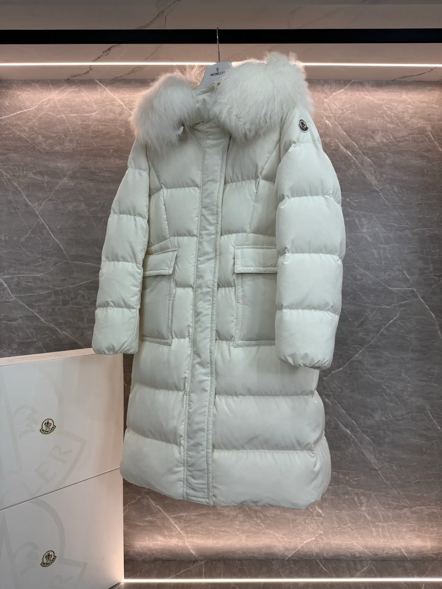 P1180 ~ New in down ⬆️Moncler* mid-length women's hooded long down jacket. The long down jacket combines exquisite materials and attention to details. The timeless and elegant fashion design can provide you with a warm and caring wearing experience. The adjustable hood embellishment, oversized wool collar, and loose fit design create a fashionable winter look. The comfortable hood is equipped with gorgeous wool decoration, full of atmosphere, and can be easily removed according to mood and weather conditions.   •Made of nylon fabric •Down filled •Hood with removable fleece collar •Two-way zipper closure •Suit pockets •Elastic cuffs Size : 0-3
