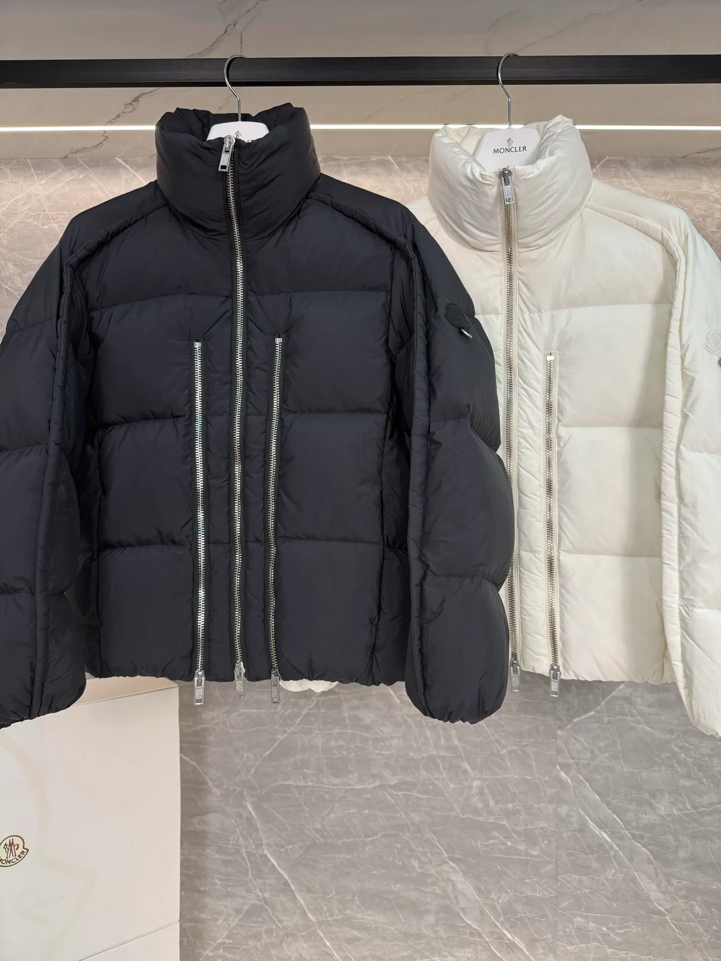 P1140 MONCLER GENIUS (Sky City Show Style) Moncler x Willow Smith YAEL Short Women's Down Jacket Jayel short down jacket is embellished with eye-catching metal accessories, highlighting the punk aesthetic of the Moncler x Willow Smith women's series.  The Moncler x Willow Smith Jayel down jacket features an extra zipper on the front, reinterpreting a signature punk detail. These functional zippers can be opened or closed and are reminiscent of artist-inspired vintage details. Made from nylon fabric that combines Moncler's heritage with Willow Smith's aesthetic, the metal ring on the logo patch is inspired by the artist's nose ring. Moncler Genius is a warm piece with a short and wide design that can be easily matched with the same color items in the series. Details Made of lightweight nylon Longue saison lining Filled with down Zip closure Snap pockets Adjustable cuffs and hem Embroidered logo patch with hoop Size: 0-3 White Black (Fairy Style)