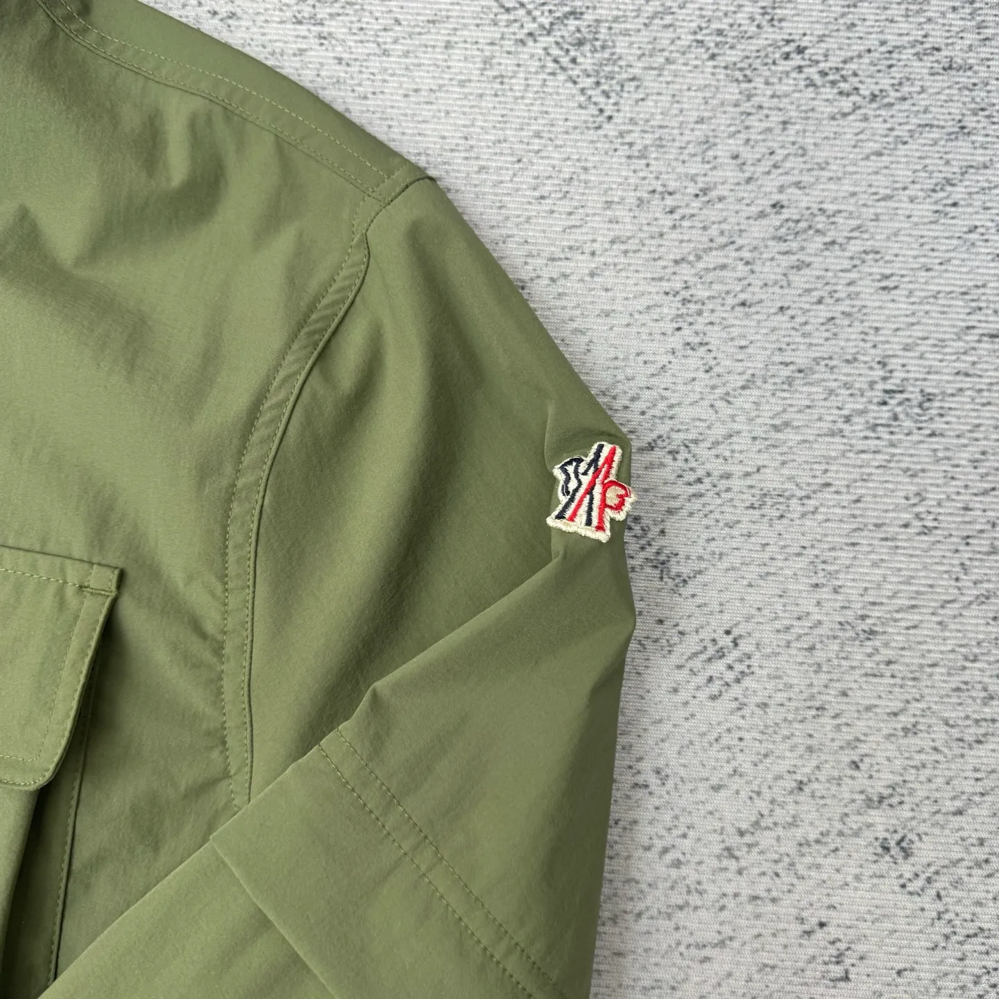 P650 Moncler Grenoble functional outdoor zippered jacket with adjustable sleeves Size: 1/2/3/4 Custom-dyed double stretch mercerized poplin Custom-dyed soft mesh pongee Excellent texture Comfortable and close to the skin Dark green inspired by plant texture The color is taken from sage leaves soaked in morning dew Precision narrative of functional pocket system Balance of function and aesthetics Iconic Moncler logo appears on the sleeves for full recognition The triangular logo of the same color is hidden into the fabric texture like a mark in the undercurrent of the deep sea. It is extremely invisible and visible. The detachable sleeve design allows for diversified outfits.