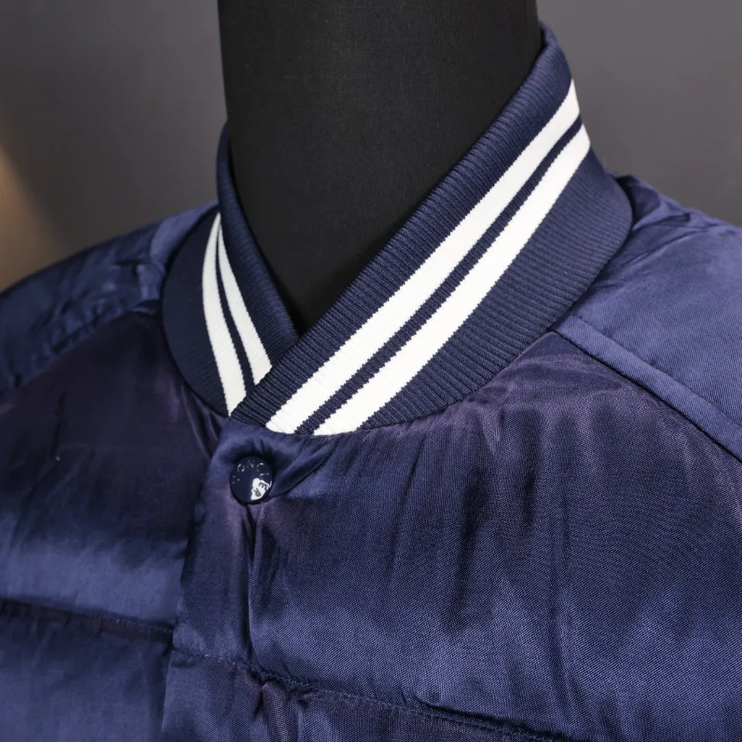 P1000 Moncler/Mask Back Logo Flying Baseball Jacket Down Jacket College retro-style baseball jacket, fashionable and stylish, made of satin nylon. After many fading treatments, it does not have the luster of ordinary satin. The overall dark color combination has the luster of satin and the unique style of Maillard colors. The entire garment is designed in the style of a flight jacket with down filling. This is the biggest highlight of moncler in the winter of 2023. The lining of the upper body is absolutely perfect. The lining is made of 50D double-sided calendered nylon breathable fabric. The filling of the whole piece of clothing is the new national standard white duck down. The filling amount of the whole piece is 280 grams. The large grid of down filling effect and the filling of white duck down are simply a warm weapon in autumn and winter.