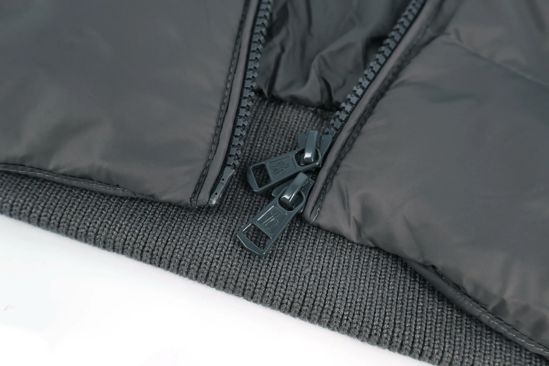 P970 Moncler muffled woolen patchwork down jacket (grey). The outer front fabric is made of 100% nylon (nylon). Its high-density structure achieves excellent windproof effect. It also has strong wear resistance and wrinkle resistance. It is scratch-free for daily wear and can be easily taken care of. The splicing design of sweaters and down jackets not only retains the thermal performance of down jackets, but also incorporates the fashion elements of sweaters, making the overall garment both practical and fashionable. High-quality material: filled with high-quality white duck down, with a filling capacity of 100g, which has excellent thermal insulation effect. At the same time, the sweater is made of wool, cashmere and other natural fibers, which are soft, comfortable and skin-friendly. The sweaters and down jackets are carefully spliced ​​to ensure comfortable wearing and are not prone to threading or velvet loss. High collar design: not only provides excellent thermal insulation effect, but also adds a unique sense of fashion, allowing the wearer to maintain style in the cold season. Stripe decoration: The stripes on the sleeve arms are like bright brush strokes, embellished on the dark gray down jacket, injecting vitality and movement into the overall look, making the clothing more eye-catching. Size:1-2-3-4-5