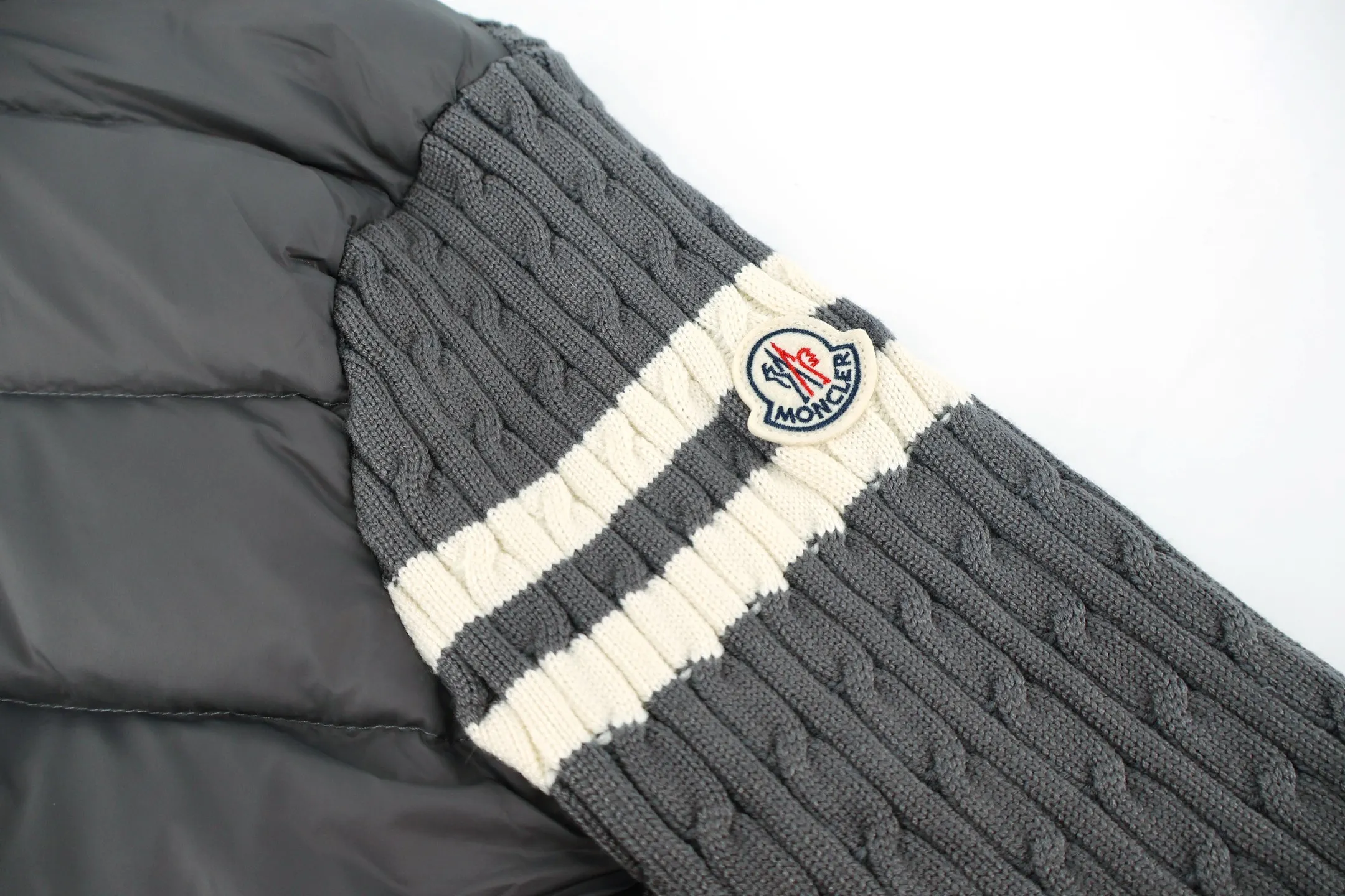 P970 Moncler muffled woolen patchwork down jacket (grey). The outer front fabric is made of 100% nylon (nylon). Its high-density structure achieves excellent windproof effect. It also has strong wear resistance and wrinkle resistance. It is scratch-free for daily wear and can be easily taken care of. The splicing design of sweaters and down jackets not only retains the thermal performance of down jackets, but also incorporates the fashion elements of sweaters, making the overall garment both practical and fashionable. High-quality material: filled with high-quality white duck down, with a filling capacity of 100g, which has excellent thermal insulation effect. At the same time, the sweater is made of wool, cashmere and other natural fibers, which are soft, comfortable and skin-friendly. The sweaters and down jackets are carefully spliced ​​to ensure comfortable wearing and are not prone to threading or velvet loss. High collar design: not only provides excellent thermal insulation effect, but also adds a unique sense of fashion, allowing the wearer to maintain style in the cold season. Stripe decoration: The stripes on the sleeve arms are like bright brush strokes, embellished on the dark gray down jacket, injecting vitality and movement into the overall look, making the clothing more eye-catching. Size:1-2-3-4-5