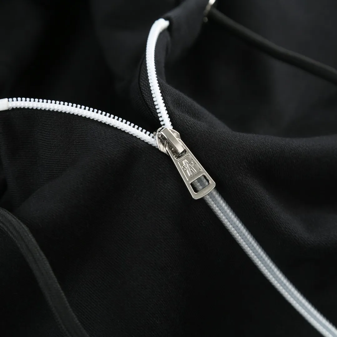 P480 MONCLER printed logo hooded sweatshirt Fabric selection: Made of lightweight turned-over velvet cotton fabric. High-density cotton fiber is used to achieve internal and external differentiation in a single layer of fabric. The outer plain weave is tight and wear-resistant, and the inner layer is formed into a short dense suede surface through a sanding process. The dense plain weave structure resists wind and splashes, the brushed suede surface is skin-friendly, and the short pile has been treated to eliminate static electricity to avoid sticking to the skin. A very small amount of grooved polyester moisture-conducting yarn is embedded in the cotton fiber, which quickly directs sweat from the inner suede surface to the outer layer for evaporation through the capillary effect, solving the problem that the inside-out suede is prone to stuffiness. Process 1: By actively intervening in the shrinkage potential of the cotton fiber, the fabric is achieved from being variable to stable, improving dimensional stability, and at the same time not prone to deformation and wrinkles.  Process 2: Use glue printing to present a high saturation pattern on the center of the cap. Apply even pressure with the scraper and print in 5 steps to ensure full penetration and coverage of the glue. After curing at high temperature, the pigment is firmly combined with the cotton fiber. The ink absorption and penetration characteristics of the cotton fiber make the pattern less likely to fall off due to friction. Accessories: One-to-one customized drawstring head, one-to-one customized zipper puller, one-to-one customized collar label, one-to-one customized badge SIZE: S M L XL