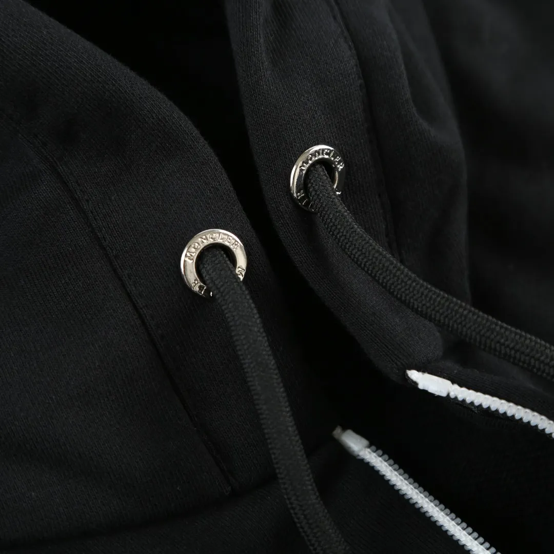 P480 MONCLER printed logo hooded sweatshirt Fabric selection: Made of lightweight turned-over velvet cotton fabric. High-density cotton fiber is used to achieve internal and external differentiation in a single layer of fabric. The outer plain weave is tight and wear-resistant, and the inner layer is formed into a short dense suede surface through a sanding process. The dense plain weave structure resists wind and splashes, the brushed suede surface is skin-friendly, and the short pile has been treated to eliminate static electricity to avoid sticking to the skin. A very small amount of grooved polyester moisture-conducting yarn is embedded in the cotton fiber, which quickly directs sweat from the inner suede surface to the outer layer for evaporation through the capillary effect, solving the problem that the inside-out suede is prone to stuffiness. Process 1: By actively intervening in the shrinkage potential of the cotton fiber, the fabric is achieved from being variable to stable, improving dimensional stability, and at the same time not prone to deformation and wrinkles.  Process 2: Use glue printing to present a high saturation pattern on the center of the cap. Apply even pressure with the scraper and print in 5 steps to ensure full penetration and coverage of the glue. After curing at high temperature, the pigment is firmly combined with the cotton fiber. The ink absorption and penetration characteristics of the cotton fiber make the pattern less likely to fall off due to friction. Accessories: One-to-one customized drawstring head, one-to-one customized zipper puller, one-to-one customized collar label, one-to-one customized badge SIZE: S M L XL