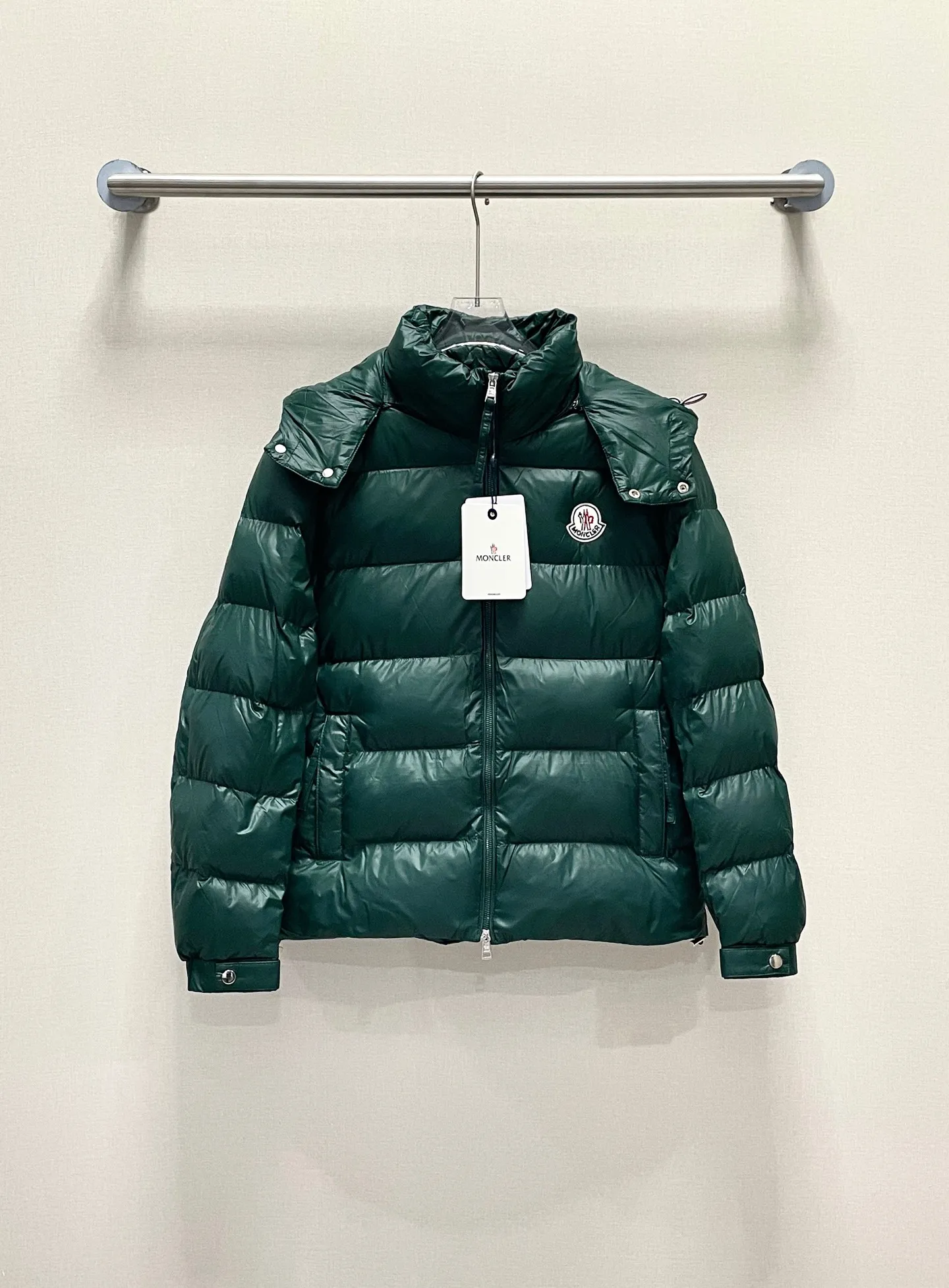 P480 Moncler/Wollaston classic lacquered down jacket. Shows the recognizable Moncler fashion style. Plays with contrasting fabrics. The shiny texture complements the warmth of the down jacket. The hooded style is detachable. It has a modern short design. The Moncler wording on the brim shows the brand charm. Color: black green