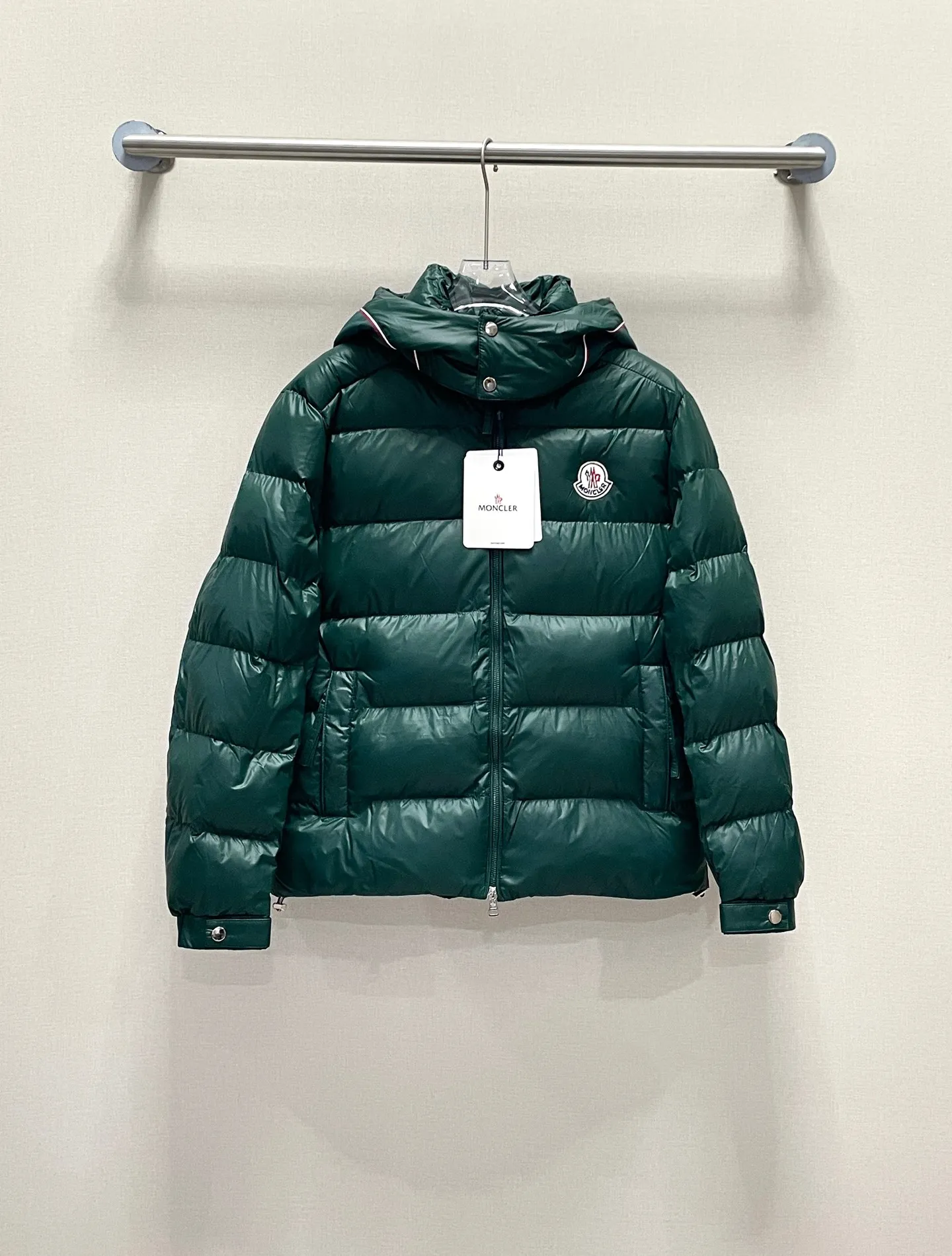 P480 Moncler/Wollaston classic lacquered down jacket. Shows the recognizable Moncler fashion style. Plays with contrasting fabrics. The shiny texture complements the warmth of the down jacket. The hooded style is detachable. It has a modern short design. The Moncler wording on the brim shows the brand charm. Color: black green
