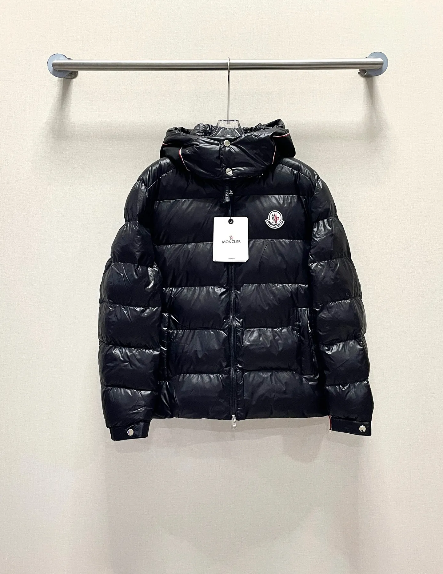 P480 Moncler/Wollaston classic lacquered down jacket. Shows the recognizable Moncler fashion style. Plays with contrasting fabrics. The shiny texture complements the warmth of the down jacket. The hooded style is detachable. It has a modern short design. The Moncler wording on the brim shows the brand charm. Color: black green