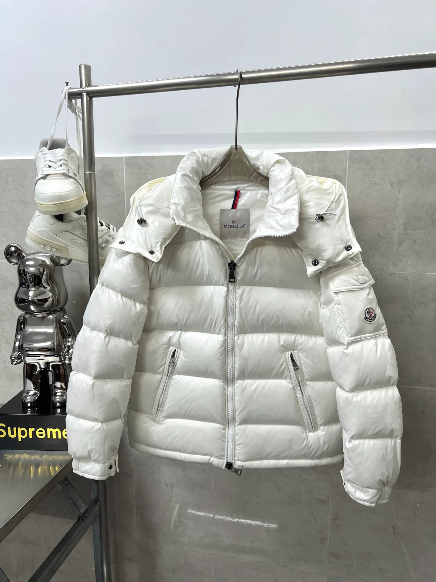 P740 Moncler Maya Zip Hooded Nylon Thermal Down Jacket This down jacket is inspired by the Italian Paninaro culture of the 1980s. Updated with a range of soft colors and molded details. Made from durable nylon paint to handle any unforeseen weather. This model features a super smart design with removable hood and performance to ensure comfort and freedom of movement. Colors: Black White Pink Size: 12345