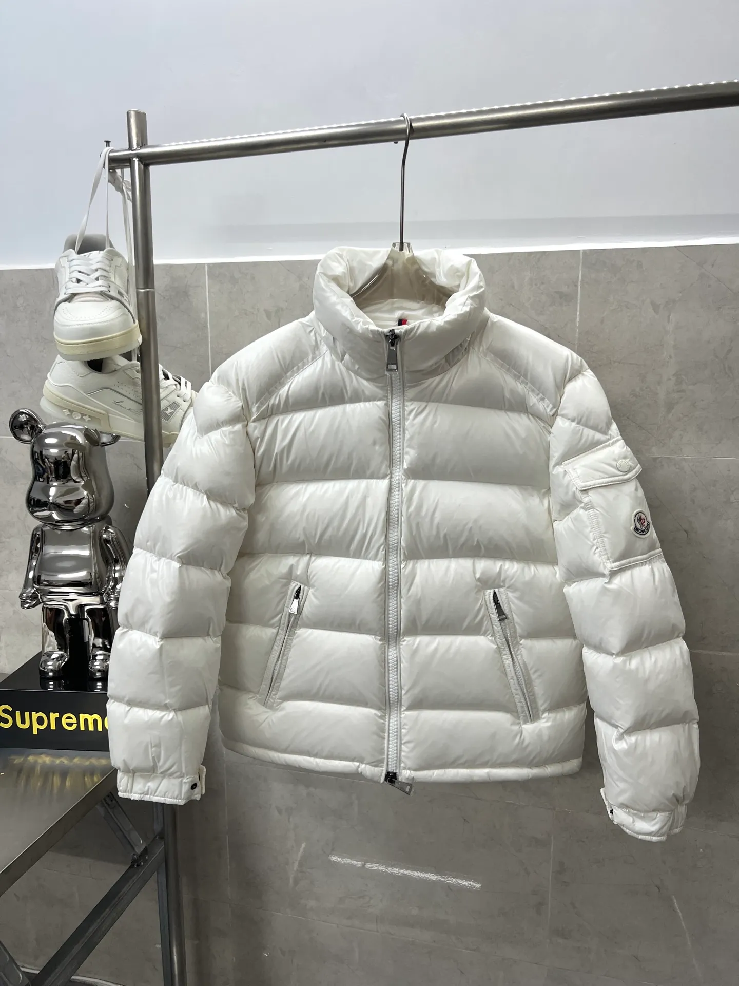 P740 Moncler Maya Zip Hooded Nylon Thermal Down Jacket This down jacket is inspired by the Italian Paninaro culture of the 1980s. Updated with a range of soft colors and molded details. Made from durable nylon paint to handle any unforeseen weather. This model features a super smart design with removable hood and performance to ensure comfort and freedom of movement. Colors: Black White Pink Size: 12345