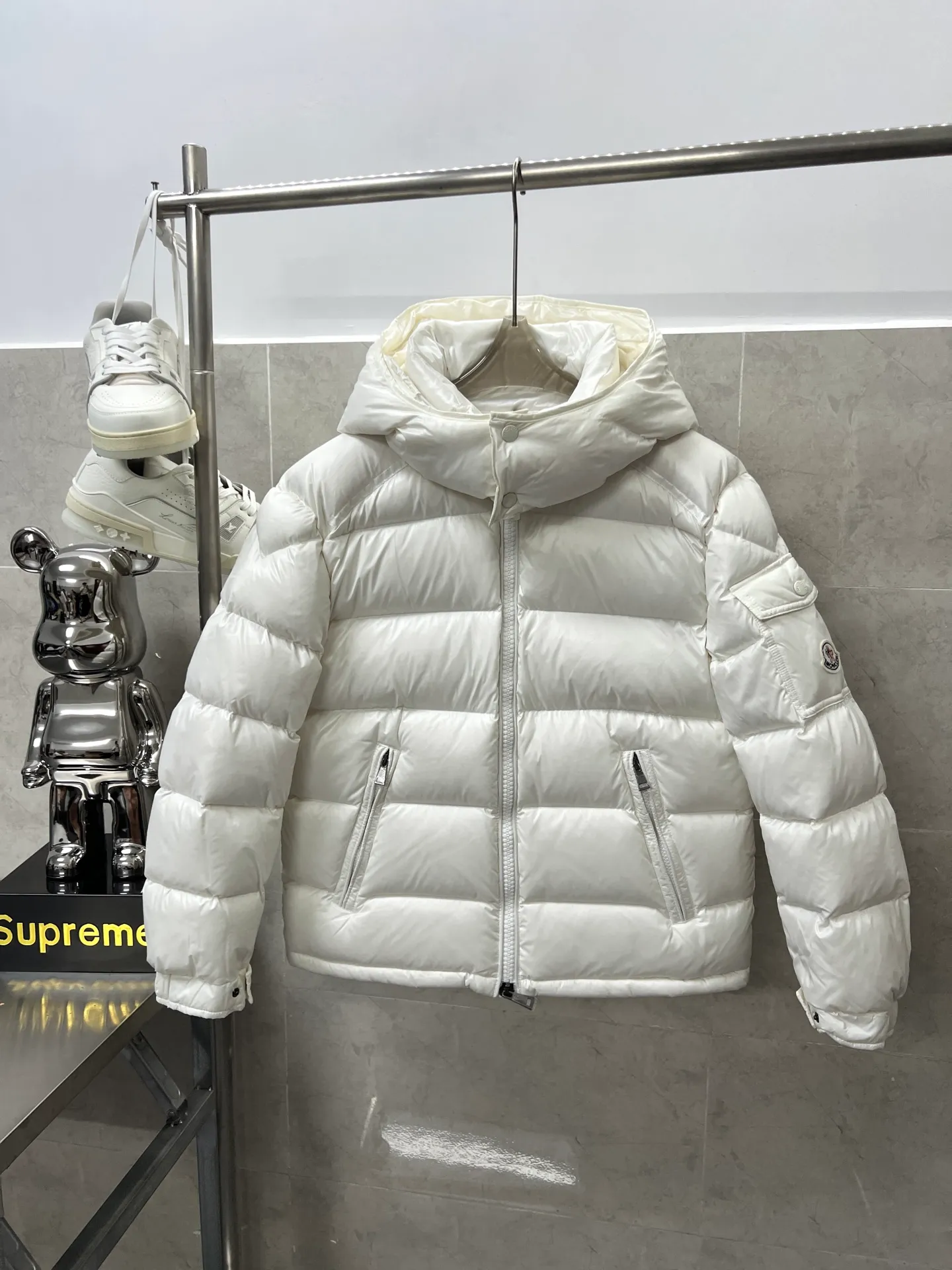 P740 Moncler Maya Zip Hooded Nylon Thermal Down Jacket This down jacket is inspired by the Italian Paninaro culture of the 1980s. Updated with a range of soft colors and molded details. Made from durable nylon paint to handle any unforeseen weather. This model features a super smart design with removable hood and performance to ensure comfort and freedom of movement. Colors: Black White Pink Size: 12345