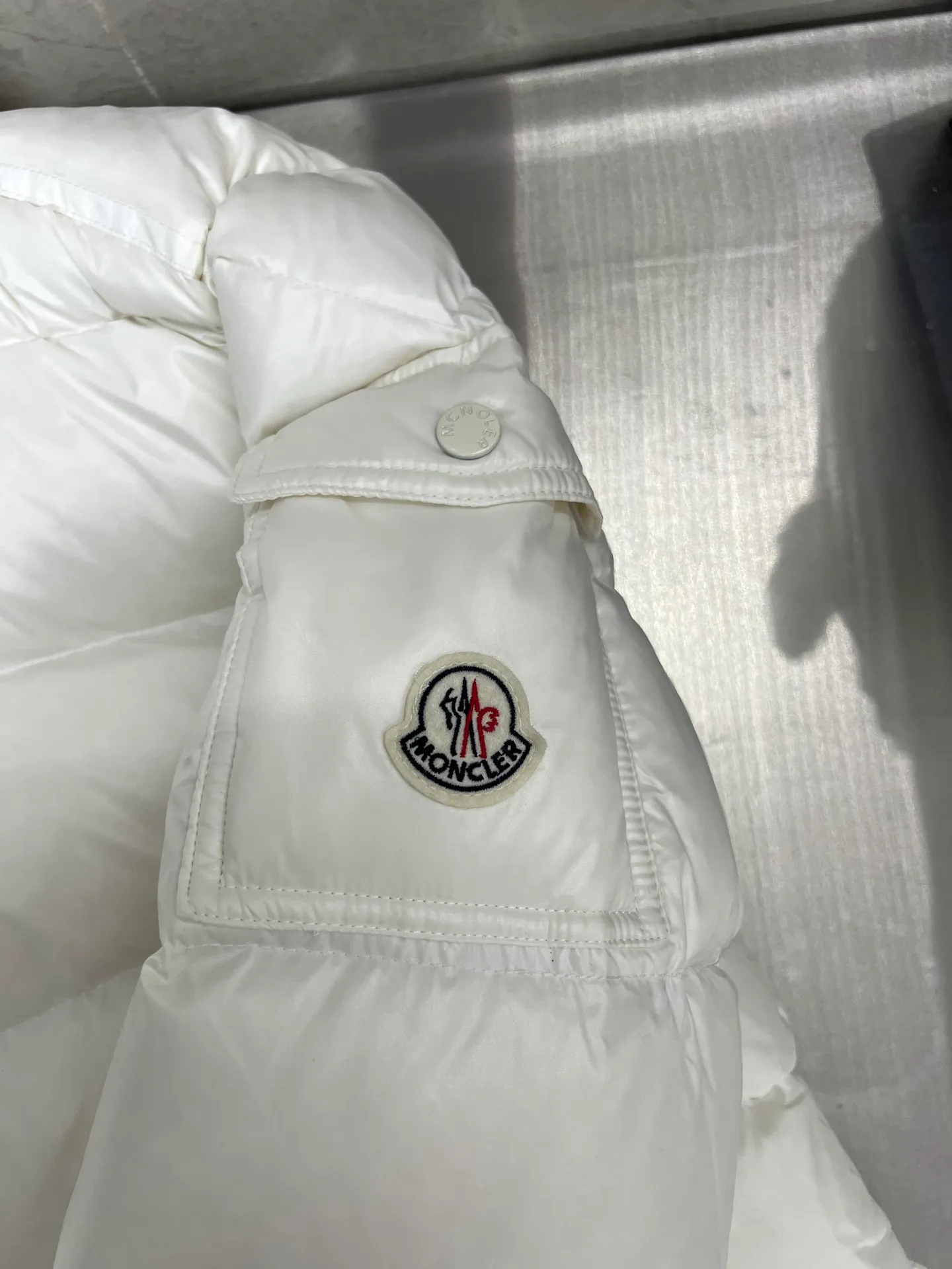 P740 Moncler Maya Zip Hooded Nylon Thermal Down Jacket This down jacket is inspired by the Italian Paninaro culture of the 1980s. Updated with a range of soft colors and molded details. Made from durable nylon paint to handle any unforeseen weather. This model features a super smart design with removable hood and performance to ensure comfort and freedom of movement. Colors: Black White Pink Size: 12345