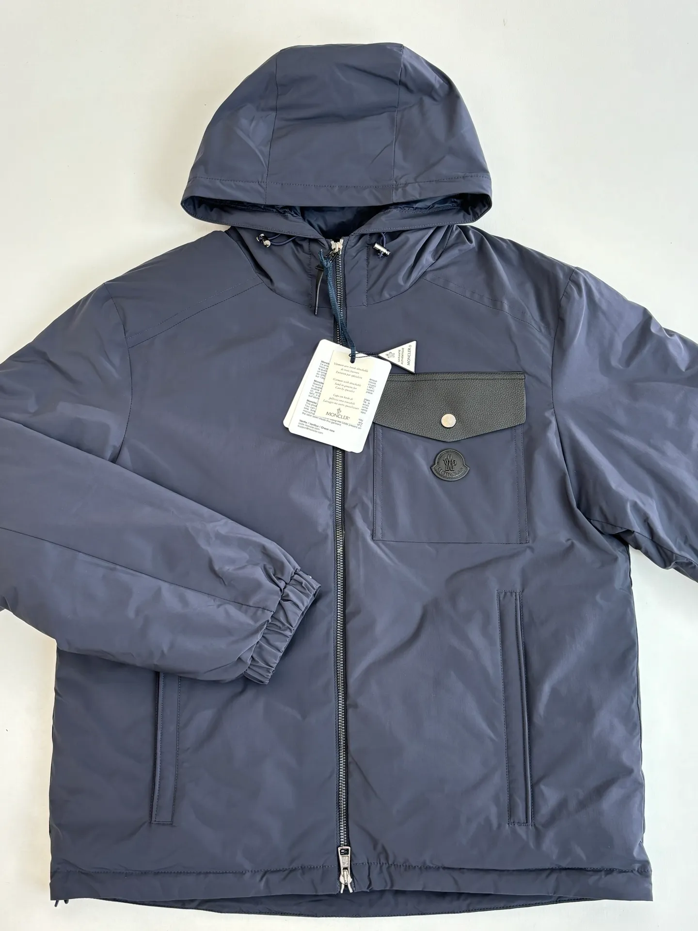 P850 Moncler*/Mask 25Fw new blue hooded down jacket is made of smooth functional nylon fabric, with both streamlined beauty and practical function. Concealed down padding provides protection when needed while maintaining a smooth silhouette. Features signature sleeve pockets and ribbed knit trim Sizes: 1/2/3/4