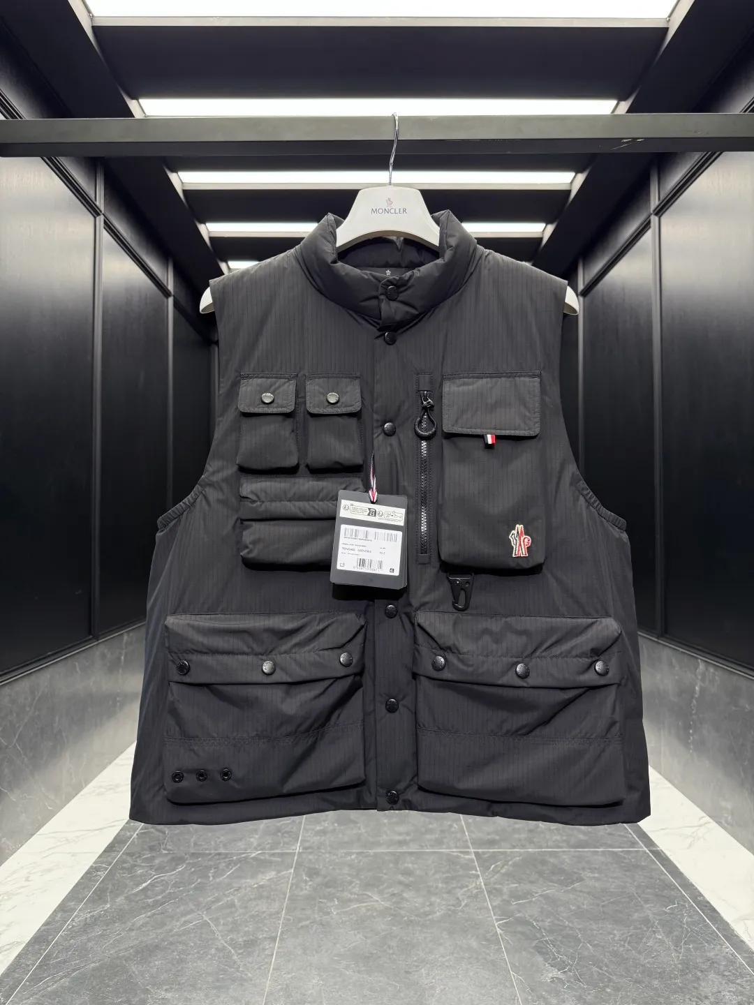 P860 Premium Down⬆️Moncler Grenoble Tongass Down Outdoor Vest. High-end Black Label Series. Original replacement fabric. Premium gooseneck filling. 🎁 Comes standard with a full set of counter gift box packaging. Upgraded original magnetic gift box. The Tongass Down Vest provides protection without being heavy, and is specially designed for outdoor activities in mild weather.  The Tongass down vest is the result of research into lightweight performance outerwear. Functional fabric is tight and durable without adding extra weight. Features a large utility pocket and carabiner clip to reduce the amount of luggage you carry. Details •Designed for outdoor activities •Made from tight fabric •Polyester lining •Down filling •Snap button closure •Utility pockets with snap, zip and Velcro closure •Drawstring hem •Front carabiner •Reflective details Size: 1-5 Cream/Light Brown/Black D00780