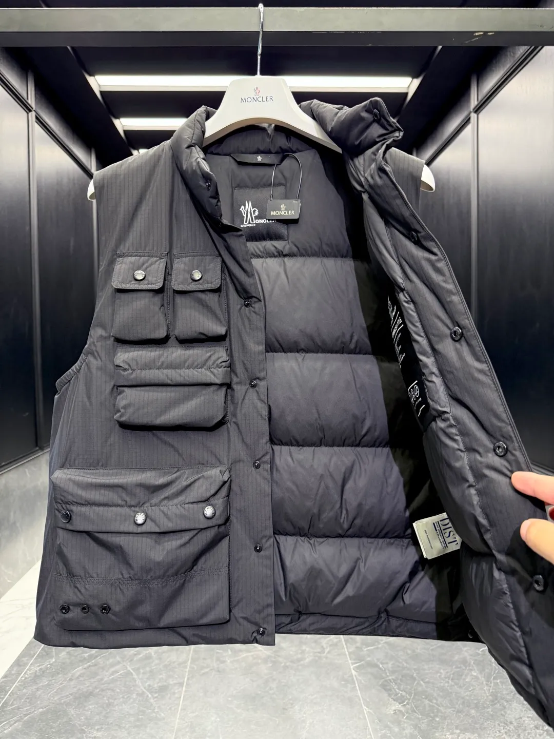 P860 Premium Down⬆️Moncler Grenoble Tongass Down Outdoor Vest. High-end Black Label Series. Original replacement fabric. Premium gooseneck filling. 🎁 Comes standard with a full set of counter gift box packaging. Upgraded original magnetic gift box. The Tongass Down Vest provides protection without being heavy, and is specially designed for outdoor activities in mild weather.  The Tongass down vest is the result of research into lightweight performance outerwear. Functional fabric is tight and durable without adding extra weight. Features a large utility pocket and carabiner clip to reduce the amount of luggage you carry. Details •Designed for outdoor activities •Made from tight fabric •Polyester lining •Down filling •Snap button closure •Utility pockets with snap, zip and Velcro closure •Drawstring hem •Front carabiner •Reflective details Size: 1-5 Cream/Light Brown/Black D00780