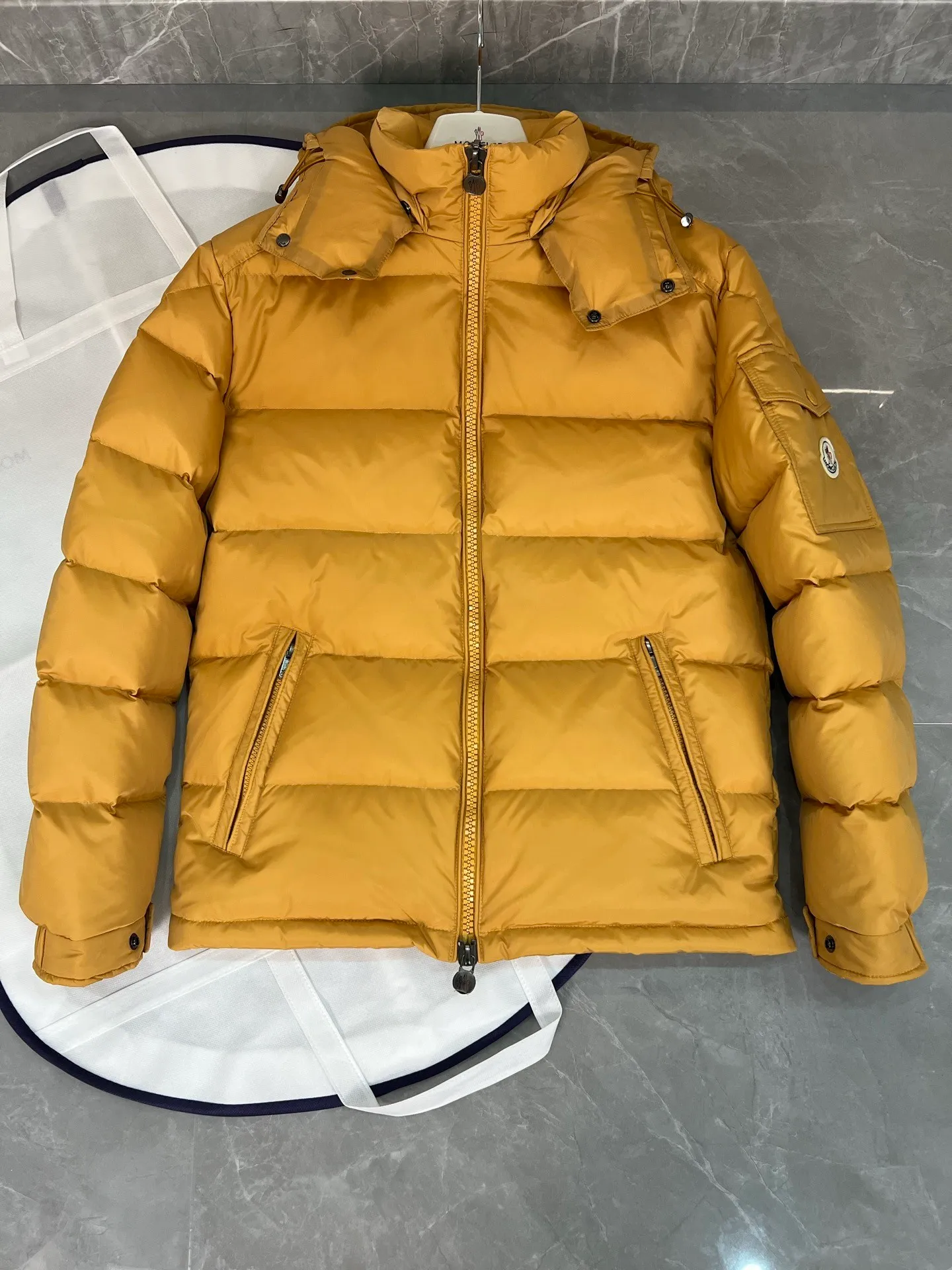 P800 (Maya hooded) Moncler's classic item, the style is highly recognizable. Made of lacquered nylon and available in a variety of colors, it's a stylish piece for casual commuting. The epitome of Moncler style. A classic cropped design that transcends seasons and styles, it features a statement silhouette, removable hood and adjustable hem. The cuffs are embellished with classic patch pockets, showing off the brand’s signature!