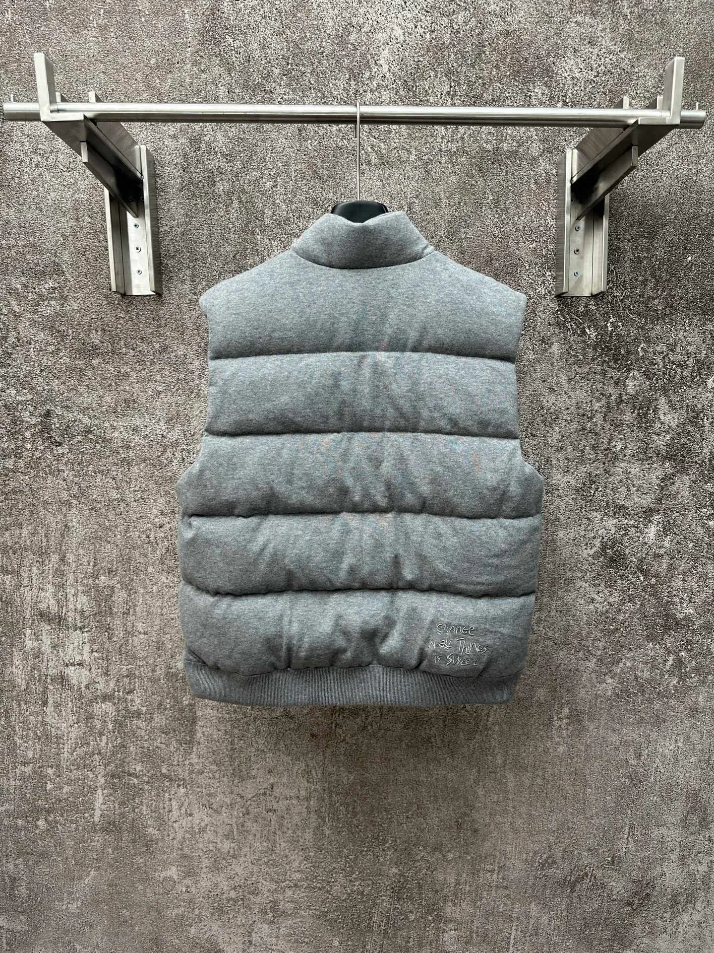 P760 MONCLER cotton embroidered down vest Fabric selection: Lightweight knitted fabric made of 100% cotton fiber. The fiber characteristics are soft to the touch. The knitted structure gives the fabric a certain degree of elasticity in the horizontal and vertical directions. Even though it is a down vest, it can move freely without any sense of restraint. The air circulates freely between the coils and has good breathability. It is not easy to accumulate moisture inside, improving the wearing experience. Lining fabric: The high-density lining is woven with ultra-fine nylon denier, with a thickness of 0.08mm to avoid increasing the overall weight and making it smooth to wear. The high-density woven structure forms a wind resistance layer to protect the thermal efficiency of the thermal layer from loss. It can also withstand the expansion pressure of down and prevent deformation and damage after long-term use.  Process: The high-precision computing system of the computerized embroidery machine controls the coordinated operation of the machine head, needle bar, and bobbin. The fabric frame moves accurately in the horizontal and vertical directions to form a stitch track. The upper and lower thread tensions are adjusted to ensure that the stitches are smooth and free of floating threads. The chest, lower front and lower back panels are decorated with three different letter embroideries. The finished product has clear patterns and no burrs on the edges.  90 national standard high-quality white duck down: Selected high-fill down, with a fill power of 650fp, light and warm, with excellent temperature locking performance and good resilience.  Accessories: One-to-one customized badges, One-to-one customized snaps, One-to-one customized three-label, One-to-one customized zipper pullers SIZE: S M L XL