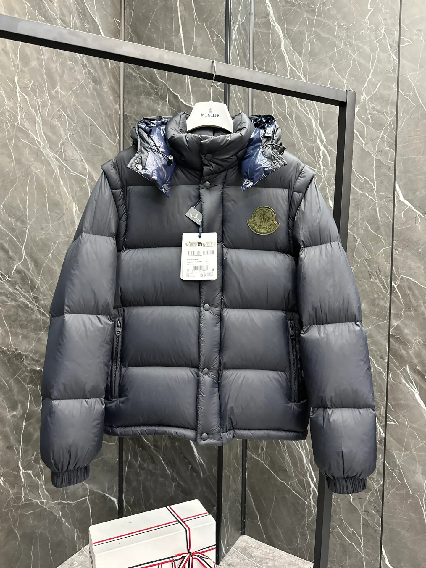 P860 Moncler Cyclone 2-in-1 down jacket. ⚠️Goose down filling, small size filling 320g➕, easy to wear in winter in one piece. Convertible/jacket/hooded vest/stand collar vest/hooded down jacket. The Cyclone down jacket comes with detachable sleeves and can be worn as a vest or jacket.  The Cyclone down jacket is a modern take on the classic silhouette of the 1980s, with a new, simple silhouette. This short down jacket is made from nylon and features easily removable sleeves, allowing you to convert the jacket into a vest. A removable hood and contrast lining complete the design. Details • Made of nylon fabric • Nylon laqué lining • Filled with down • Detachable hood and sleeves • Zipper and snap closure • Zipper pockets • Elastic cuffs • Elastic drawstring hem Size: 1-5 Dark Navy Chocolate 2 colors in Couple size.