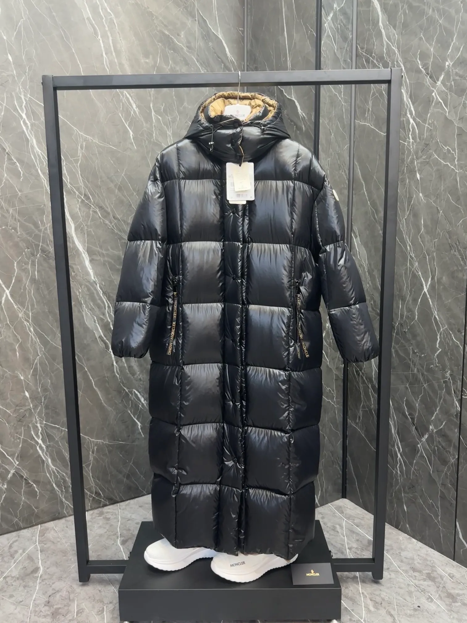 Premium down  Parnaiba's long down jacket features graphic details and bold color blocking in signature patented nylon. The eye-catching design features large grille quilting and contrasting lining. The removable hood and adjustable hem make it easy to personalize the style, and the color-blocked pattern highlights the highly recognizable Moncler vibe. Details •Made from nylon laqué fabric •Contrast nylon laqué lining •Detachable hood with zipper and drawstring •Zip closure with black patented snap fastener •Zip pocket Size: 0-4. Original runs large. D98108078950