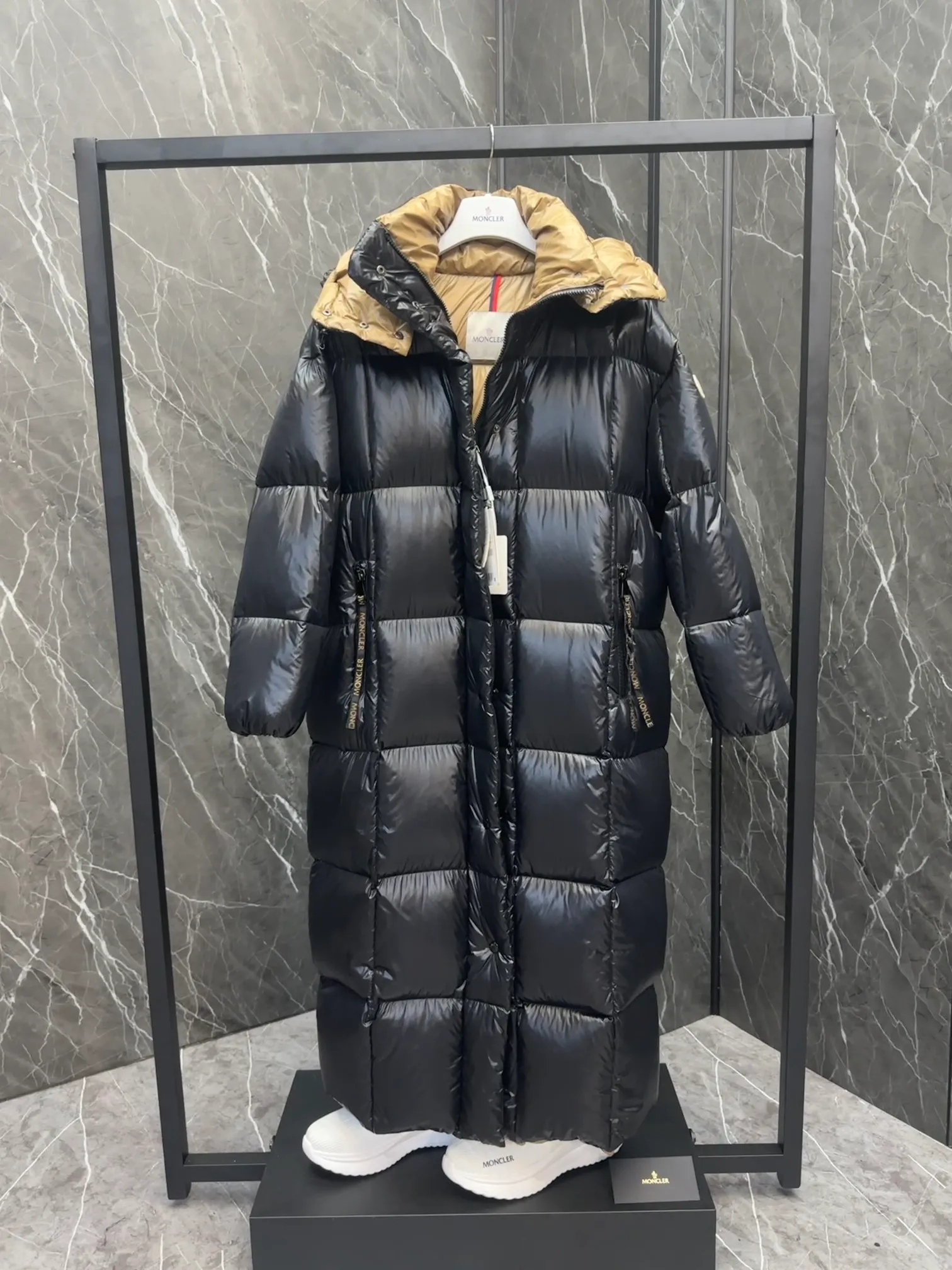 Premium down  Parnaiba's long down jacket features graphic details and bold color blocking in signature patented nylon. The eye-catching design features large grille quilting and contrasting lining. The removable hood and adjustable hem make it easy to personalize the style, and the color-blocked pattern highlights the highly recognizable Moncler vibe. Details •Made from nylon laqué fabric •Contrast nylon laqué lining •Detachable hood with zipper and drawstring •Zip closure with black patented snap fastener •Zip pocket Size: 0-4. Original runs large. D98108078950