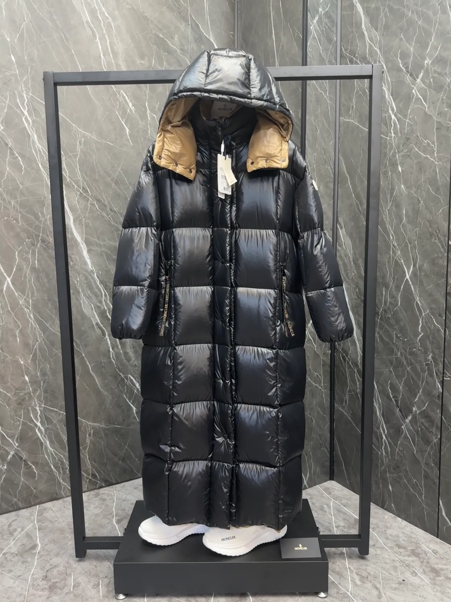 Premium down  Parnaiba's long down jacket features graphic details and bold color blocking in signature patented nylon. The eye-catching design features large grille quilting and contrasting lining. The removable hood and adjustable hem make it easy to personalize the style, and the color-blocked pattern highlights the highly recognizable Moncler vibe. Details •Made from nylon laqué fabric •Contrast nylon laqué lining •Detachable hood with zipper and drawstring •Zip closure with black patented snap fastener •Zip pocket Size: 0-4. Original runs large. D98108078950