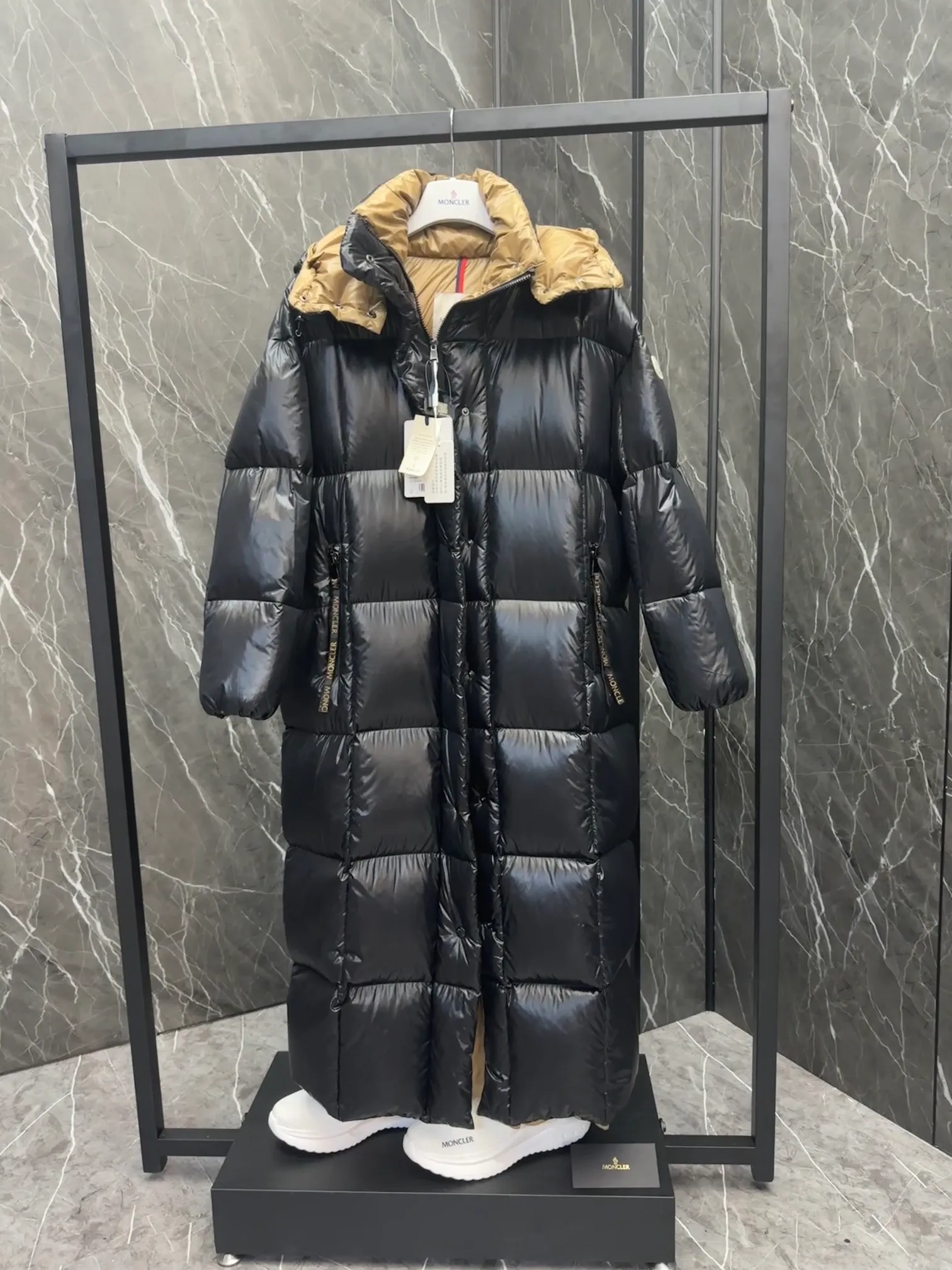 Premium down  Parnaiba's long down jacket features graphic details and bold color blocking in signature patented nylon. The eye-catching design features large grille quilting and contrasting lining. The removable hood and adjustable hem make it easy to personalize the style, and the color-blocked pattern highlights the highly recognizable Moncler vibe. Details •Made from nylon laqué fabric •Contrast nylon laqué lining •Detachable hood with zipper and drawstring •Zip closure with black patented snap fastener •Zip pocket Size: 0-4. Original runs large. D98108078950