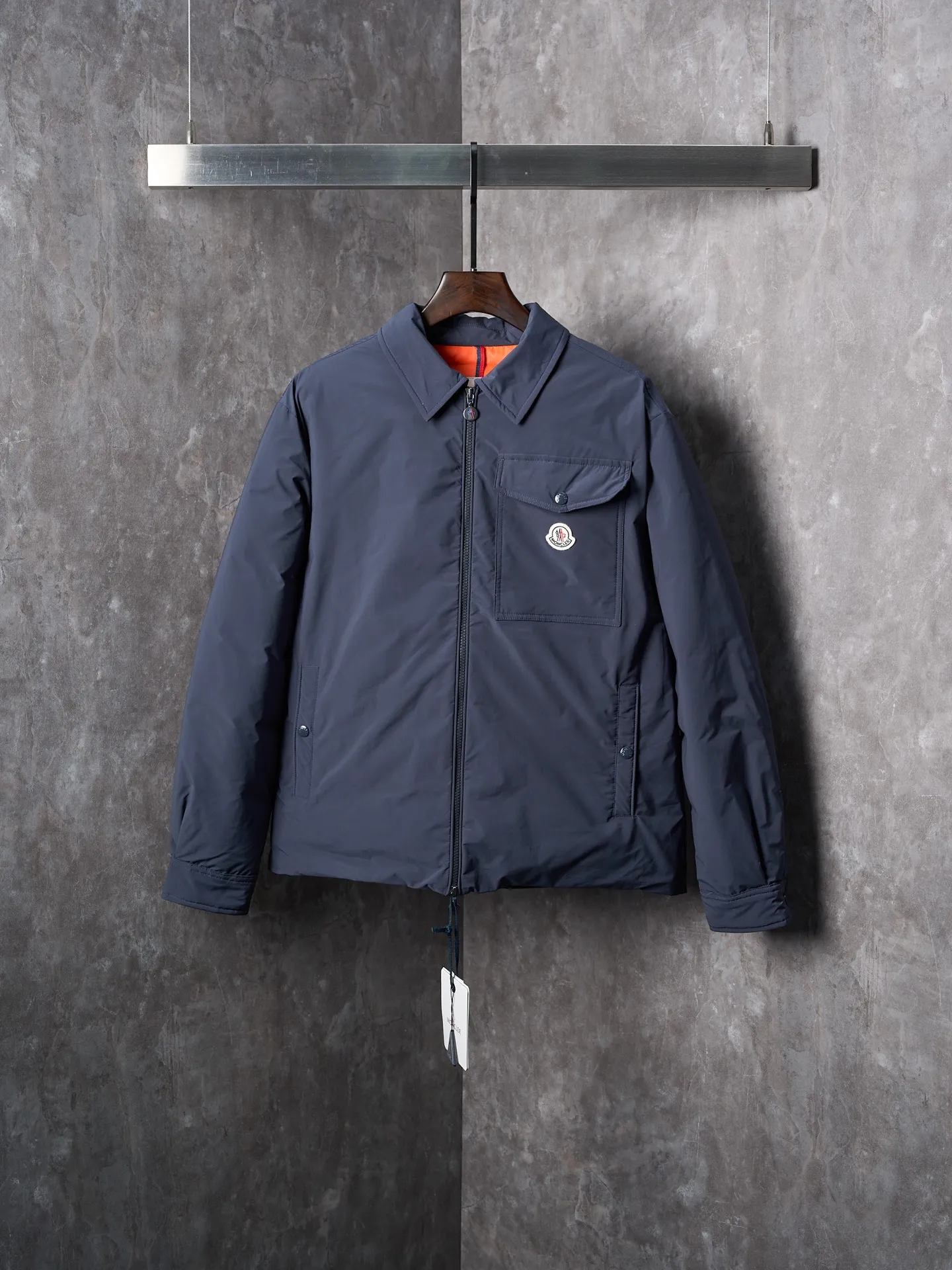 P900 Actual hanging auction] MONCLER/Muzzled Pocket Label Lapel Jacket Down Jacket [Ready Stock] 1 2 3 4 Made of 90 white duck down with a weight of 200g to ensure excellent thermal insulation performance. After strict screening and processing, the velvet is not easy to drill, ensuring durability. After selecting 100% polyester fiber and undergoing microfiberization treatment, the individual fibers become extremely fine, which greatly increases the fiber surface area, making the fabric soft, smooth, and close to natural fibers in touch. The high-density textile method makes the structure tight, thus giving it a certain degree of wrinkle resistance, windproof warmth and wear resistance.  The inner lining is made of 100% nylon, and the high-density and tight weaving process prevents fine lint from getting out of the gaps in the fabric. The smooth surface improves the putting on and taking off experience, and the excellent wear and tear resistance ensures damage caused by frequent use, while the light and soft texture does not affect the overall weight.  Details: 1. It adopts a neat shirt style, which is more slim and smart compared to conventional down jackets. It is suitable for business casual or various occasions. 2. Orange lining: The interior uses high-saturation orange lining, which brings a surprising visual impact when wearing. 3. The flap chest patch pocket located on the left chest is not only practical, but also greatly improves the sophistication and recognition of the clothing. The flip design can better protect the contents of the bag. 4. The front of the clothing adopts a smooth zipper as the main opening and closing method to ensure wind resistance and warmth, and is easy to put on and take off. 5. The cuffs are opened and closed with buttons, which can accurately adjust the tightness of the cuffs to prevent cold wind from pouring in. At the same time, it perfectly echoes the overall shirt style and looks particularly elegant. 6. The interior is quilted with imported No. 7 needles + anti-velvet thin threads, with 13 stitches every three centimeters. The stitches are straight and there is no skipped stitches.