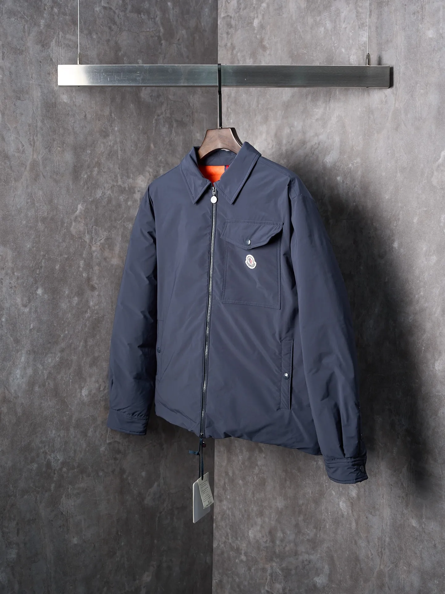 P900 Actual hanging auction] MONCLER/Muzzled Pocket Label Lapel Jacket Down Jacket [Ready Stock] 1 2 3 4 Made of 90 white duck down with a weight of 200g to ensure excellent thermal insulation performance. After strict screening and processing, the velvet is not easy to drill, ensuring durability. After selecting 100% polyester fiber and undergoing microfiberization treatment, the individual fibers become extremely fine, which greatly increases the fiber surface area, making the fabric soft, smooth, and close to natural fibers in touch. The high-density textile method makes the structure tight, thus giving it a certain degree of wrinkle resistance, windproof warmth and wear resistance.  The inner lining is made of 100% nylon, and the high-density and tight weaving process prevents fine lint from getting out of the gaps in the fabric. The smooth surface improves the putting on and taking off experience, and the excellent wear and tear resistance ensures damage caused by frequent use, while the light and soft texture does not affect the overall weight.  Details: 1. It adopts a neat shirt style, which is more slim and smart compared to conventional down jackets. It is suitable for business casual or various occasions. 2. Orange lining: The interior uses high-saturation orange lining, which brings a surprising visual impact when wearing. 3. The flap chest patch pocket located on the left chest is not only practical, but also greatly improves the sophistication and recognition of the clothing. The flip design can better protect the contents of the bag. 4. The front of the clothing adopts a smooth zipper as the main opening and closing method to ensure wind resistance and warmth, and is easy to put on and take off. 5. The cuffs are opened and closed with buttons, which can accurately adjust the tightness of the cuffs to prevent cold wind from pouring in. At the same time, it perfectly echoes the overall shirt style and looks particularly elegant. 6. The interior is quilted with imported No. 7 needles + anti-velvet thin threads, with 13 stitches every three centimeters. The stitches are straight and there is no skipped stitches.