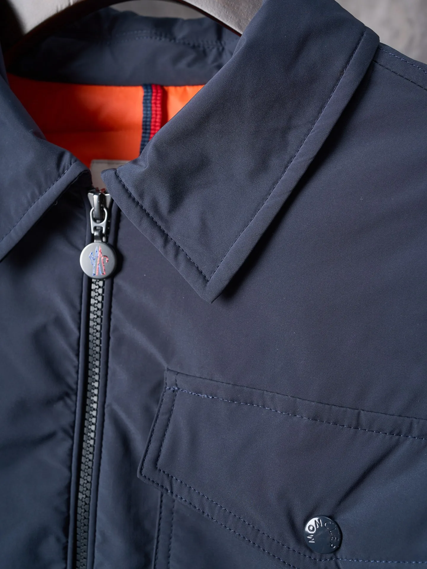 P900 Actual hanging auction] MONCLER/Muzzled Pocket Label Lapel Jacket Down Jacket [Ready Stock] 1 2 3 4 Made of 90 white duck down with a weight of 200g to ensure excellent thermal insulation performance. After strict screening and processing, the velvet is not easy to drill, ensuring durability. After selecting 100% polyester fiber and undergoing microfiberization treatment, the individual fibers become extremely fine, which greatly increases the fiber surface area, making the fabric soft, smooth, and close to natural fibers in touch. The high-density textile method makes the structure tight, thus giving it a certain degree of wrinkle resistance, windproof warmth and wear resistance.  The inner lining is made of 100% nylon, and the high-density and tight weaving process prevents fine lint from getting out of the gaps in the fabric. The smooth surface improves the putting on and taking off experience, and the excellent wear and tear resistance ensures damage caused by frequent use, while the light and soft texture does not affect the overall weight.  Details: 1. It adopts a neat shirt style, which is more slim and smart compared to conventional down jackets. It is suitable for business casual or various occasions. 2. Orange lining: The interior uses high-saturation orange lining, which brings a surprising visual impact when wearing. 3. The flap chest patch pocket located on the left chest is not only practical, but also greatly improves the sophistication and recognition of the clothing. The flip design can better protect the contents of the bag. 4. The front of the clothing adopts a smooth zipper as the main opening and closing method to ensure wind resistance and warmth, and is easy to put on and take off. 5. The cuffs are opened and closed with buttons, which can accurately adjust the tightness of the cuffs to prevent cold wind from pouring in. At the same time, it perfectly echoes the overall shirt style and looks particularly elegant. 6. The interior is quilted with imported No. 7 needles + anti-velvet thin threads, with 13 stitches every three centimeters. The stitches are straight and there is no skipped stitches.