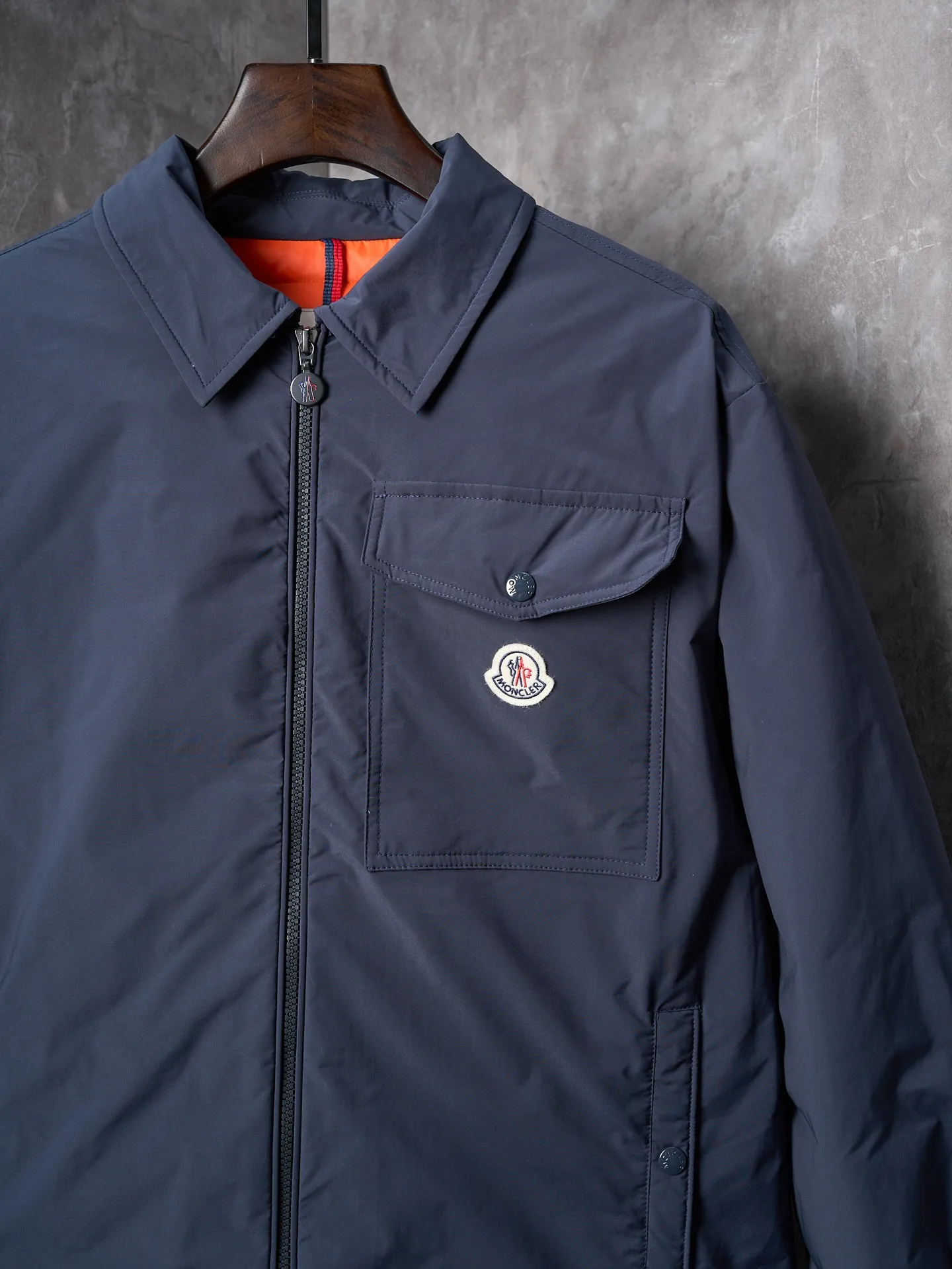 P900 Actual hanging auction] MONCLER/Muzzled Pocket Label Lapel Jacket Down Jacket [Ready Stock] 1 2 3 4 Made of 90 white duck down with a weight of 200g to ensure excellent thermal insulation performance. After strict screening and processing, the velvet is not easy to drill, ensuring durability. After selecting 100% polyester fiber and undergoing microfiberization treatment, the individual fibers become extremely fine, which greatly increases the fiber surface area, making the fabric soft, smooth, and close to natural fibers in touch. The high-density textile method makes the structure tight, thus giving it a certain degree of wrinkle resistance, windproof warmth and wear resistance.  The inner lining is made of 100% nylon, and the high-density and tight weaving process prevents fine lint from getting out of the gaps in the fabric. The smooth surface improves the putting on and taking off experience, and the excellent wear and tear resistance ensures damage caused by frequent use, while the light and soft texture does not affect the overall weight.  Details: 1. It adopts a neat shirt style, which is more slim and smart compared to conventional down jackets. It is suitable for business casual or various occasions. 2. Orange lining: The interior uses high-saturation orange lining, which brings a surprising visual impact when wearing. 3. The flap chest patch pocket located on the left chest is not only practical, but also greatly improves the sophistication and recognition of the clothing. The flip design can better protect the contents of the bag. 4. The front of the clothing adopts a smooth zipper as the main opening and closing method to ensure wind resistance and warmth, and is easy to put on and take off. 5. The cuffs are opened and closed with buttons, which can accurately adjust the tightness of the cuffs to prevent cold wind from pouring in. At the same time, it perfectly echoes the overall shirt style and looks particularly elegant. 6. The interior is quilted with imported No. 7 needles + anti-velvet thin threads, with 13 stitches every three centimeters. The stitches are straight and there is no skipped stitches.