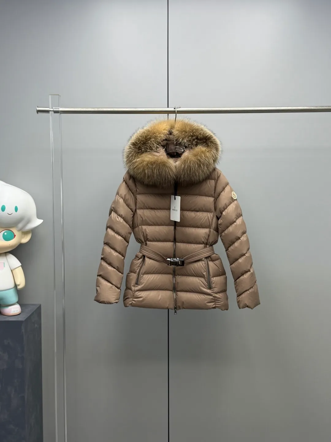 P1180 MONCLER 2025FW Women's Cupidone Large Fur Collar Small Waist Slim Belt Hooded Down Jacket Three-dimensional girdle design: innovatively uses an adjustable belt to accurately outline women's waist curves, effectively enhance the waistline, reshape the golden body proportions, and completely bid farewell to the bloated feeling of traditional down jackets. A-line micro silhouette: tall and straight upper body, slightly flared hem, elegance and agility coexist. Symbol of luxury | Oversized fur collar, choose a large fur collar: The brim of the hat is decorated with a luxurious and fluffy large fur collar, which not only provides the ultimate in warmth and care, but also demonstrates extraordinary taste and strong aura. High-quality fleece core: uniform fleece filling and temperature locking technology to ensure that it remains warm as spring in extremely cold environments. Whether paired with skinny jeans to create a casual fashion, or worn under a dress to show elegance. Color: Milky white, brown, black Size: 1-2-3-4