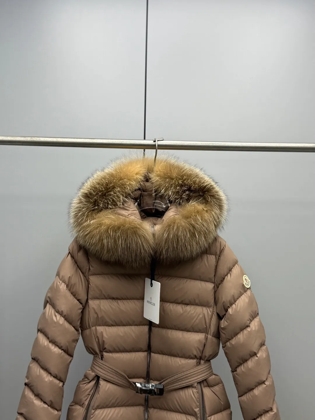 P1180 MONCLER 2025FW Women's Cupidone Large Fur Collar Small Waist Slim Belt Hooded Down Jacket Three-dimensional girdle design: innovatively uses an adjustable belt to accurately outline women's waist curves, effectively enhance the waistline, reshape the golden body proportions, and completely bid farewell to the bloated feeling of traditional down jackets. A-line micro silhouette: tall and straight upper body, slightly flared hem, elegance and agility coexist. Symbol of luxury | Oversized fur collar, choose a large fur collar: The brim of the hat is decorated with a luxurious and fluffy large fur collar, which not only provides the ultimate in warmth and care, but also demonstrates extraordinary taste and strong aura. High-quality fleece core: uniform fleece filling and temperature locking technology to ensure that it remains warm as spring in extremely cold environments. Whether paired with skinny jeans to create a casual fashion, or worn under a dress to show elegance. Color: Milky white, brown, black Size: 1-2-3-4