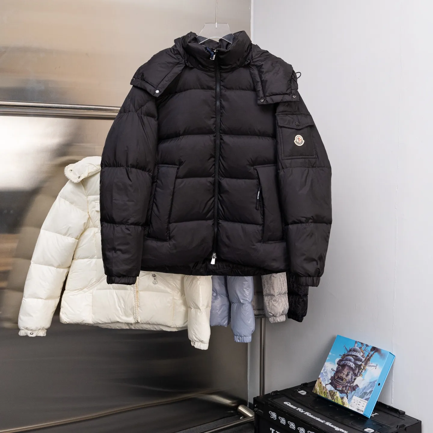 P880 Special down ⬆️Moncler Couyere (hooded, removable, variable stand-up collar jacket) men's hooded short down jacket. Forgive me for being so late. I haven't found any finished fabrics on the market that I'm satisfied with. It took a long time to customize the original replacement fabric. The original purchase and development. Goose down filling. The barcode is complete for every year and corresponds to the official website. The tag has built-in NFC electronic induction anti-counterfeiting. Supports multiple anti-counterfeiting verifications. 🎁The factory comes standard with a full set of counter gift box packaging. (Original airplane box, original shopping bag, original dust-proof grass, original hanger, original thank you card, original ribbon, upgraded original oversized magnetic gift box.) The Couyere short down jacket is durable and practical, provides functional warmth and care, and will accompany you to meet challenges.  Product Details: The Couyere is a durable down jacket made from a fine fabric that's durable and functional, with velvet resistance and functionality. The short design creates a sculpted silhouette, and padded pockets add a modern feel. The sleeves are embellished with signature patch pockets, a nod to the classic Moncler Maya down jacket.  Details: •Made from fine ripstop fabric •Microfabric lining •Down filling •Removable, adjustable hood •Zip closure •Zip pockets •Snap-buttoned sleeve pockets •Elasticized cuffs •Drawstring hem Size: 1-5 Black