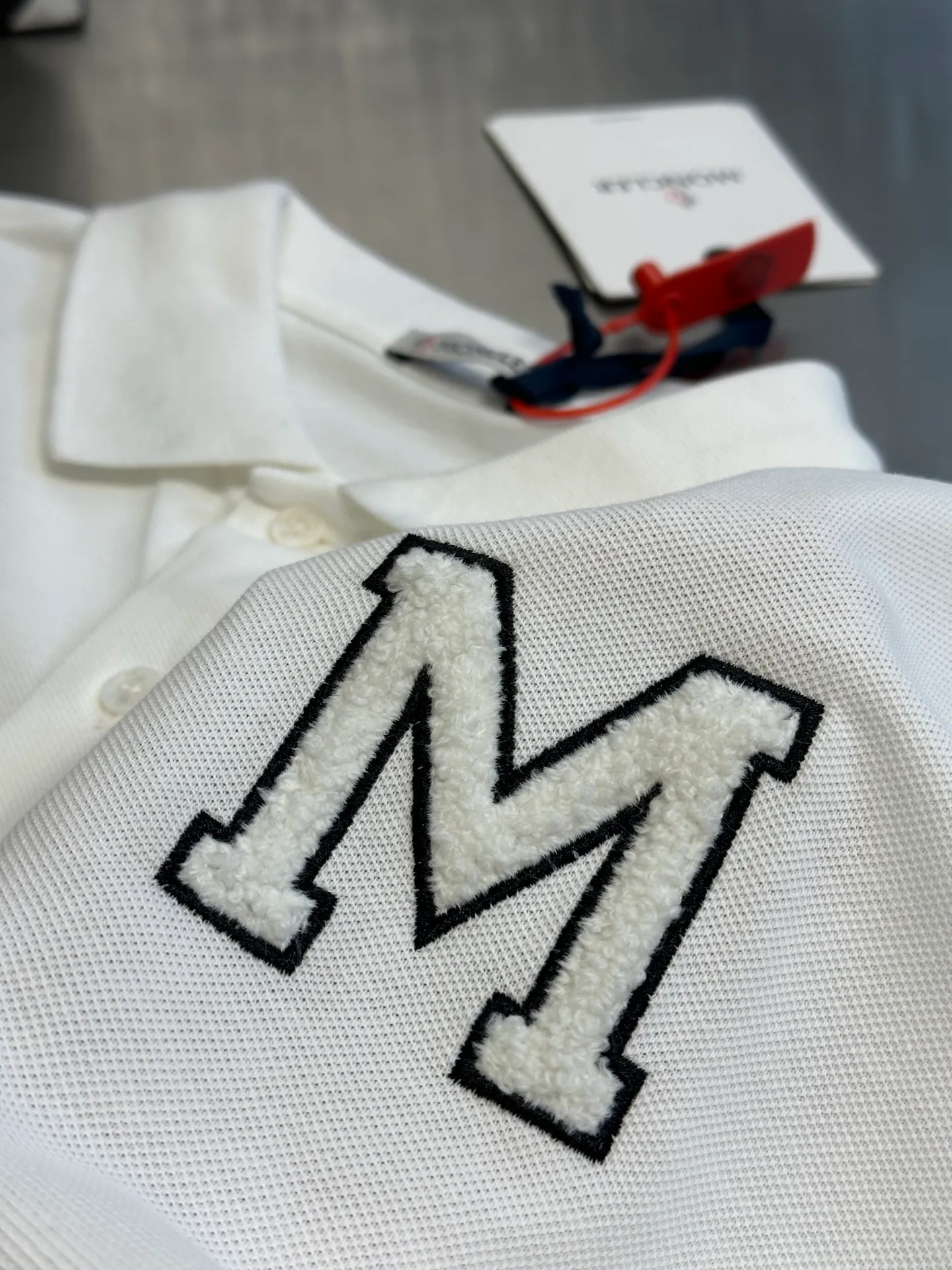 P280 Moncler terry embroidered Polo shirt, custom-made piqué pure cotton sateen, the M letter on the chest is outlined on navy blue with navy blue thread, giving the Polo shirt an instant relief-like spatial layering, which complements the badges on the sleeves and highlights the brand style.  It adopts towel embroidery technology, a traditional hand-made embroidery technology, which uses needle method to embroider. It is completed by changing the hooking action of a special machine head, and the coils are interlocked one by one, thus bringing a towel-like texture and effect.  size：s m l xl