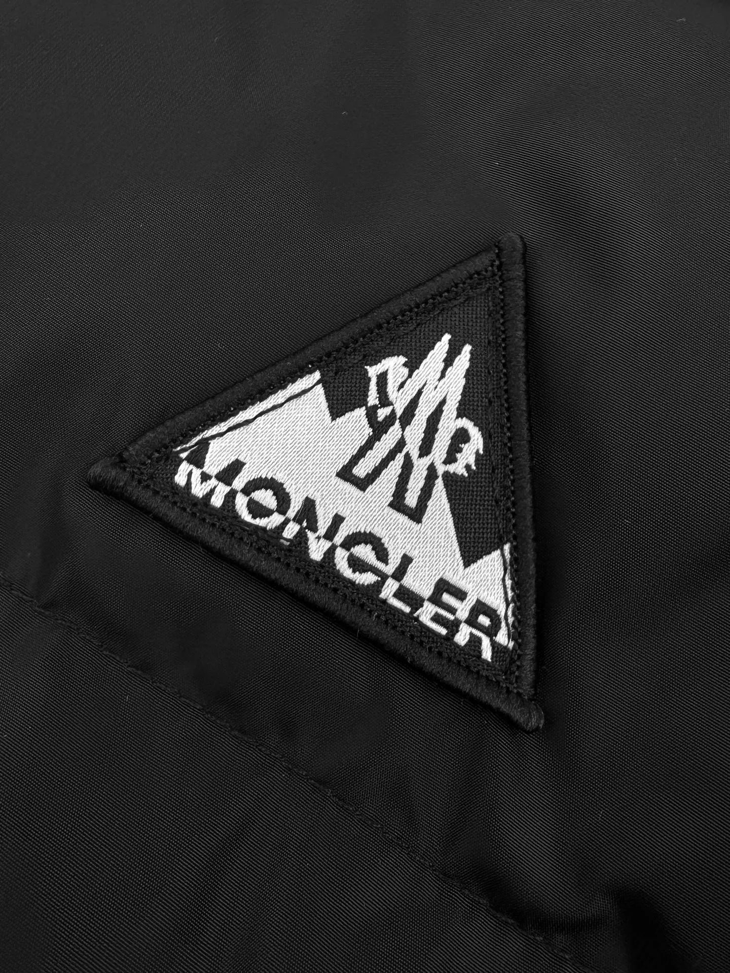 P780 Moncler logo woven splicing down jacket, custom matte lattice air shield down and 300D high-density calendered coating, using the new national standard 90 white duck down (welcome to test), full of down, full of warmth, light and fluffy, with a pure and extreme black tone, exuding an irresistible charm. The Monlcer triangle logo is embellished on the chest. The power aesthetics of the minimalist logo. The concentrated down filling in the front area creates dynamic insulation for the core heat dissipation zone of the human body. The hooded down is a moving warm flow barrier for the head and neck. It forms a thermal energy circulation system with the front panel. The elastic woven sleeves provide freedom of movement with a sense of compression, forming a relaxed and warm philosophy. The real high-end is to let function become the footnote of style. Process 1: Computer mechanical down filling. First, make the liner pattern to determine the filling area and determine the gram weight of down per square meter according to the original three-dimensional effect to calculate the amount of down filling for each piece. The computer down filling machine uses a digital weighing unit. Achieve stable measurement Process 2: 3D three-dimensional quilting technology. With the help of the programming system of the CNC quilting machine, the down in different areas is accurately separated to ensure that the filling is evenly fixed after sewing to avoid agglomeration or shifting. Process 3: Computer template machine line running process. The computer template machine line running process shows extremely high neatness and smoothness. The craftsman accurately controls the size during the operation to ensure that each row line meets the design requirements. The lines of the entire template are smooth and unified, clean and beautiful. Process 4: Triple locking and five-thread dense stitching process. Main seam locking + diagonal reinforcement + raw edge wrapping. Triple structure to form a three-dimensional protective net at the edge of the fabric to avoid stitch breakage. Paving materials: Customized 1:1 Moncler zipper. Customized 1:1 Moncler rope loop. Customized 1:1 Moncler logo. Customized 1:1 Moncler eyelet. Customized 1:1 Moncler trademark. Size: S M L XL Style number: 25378