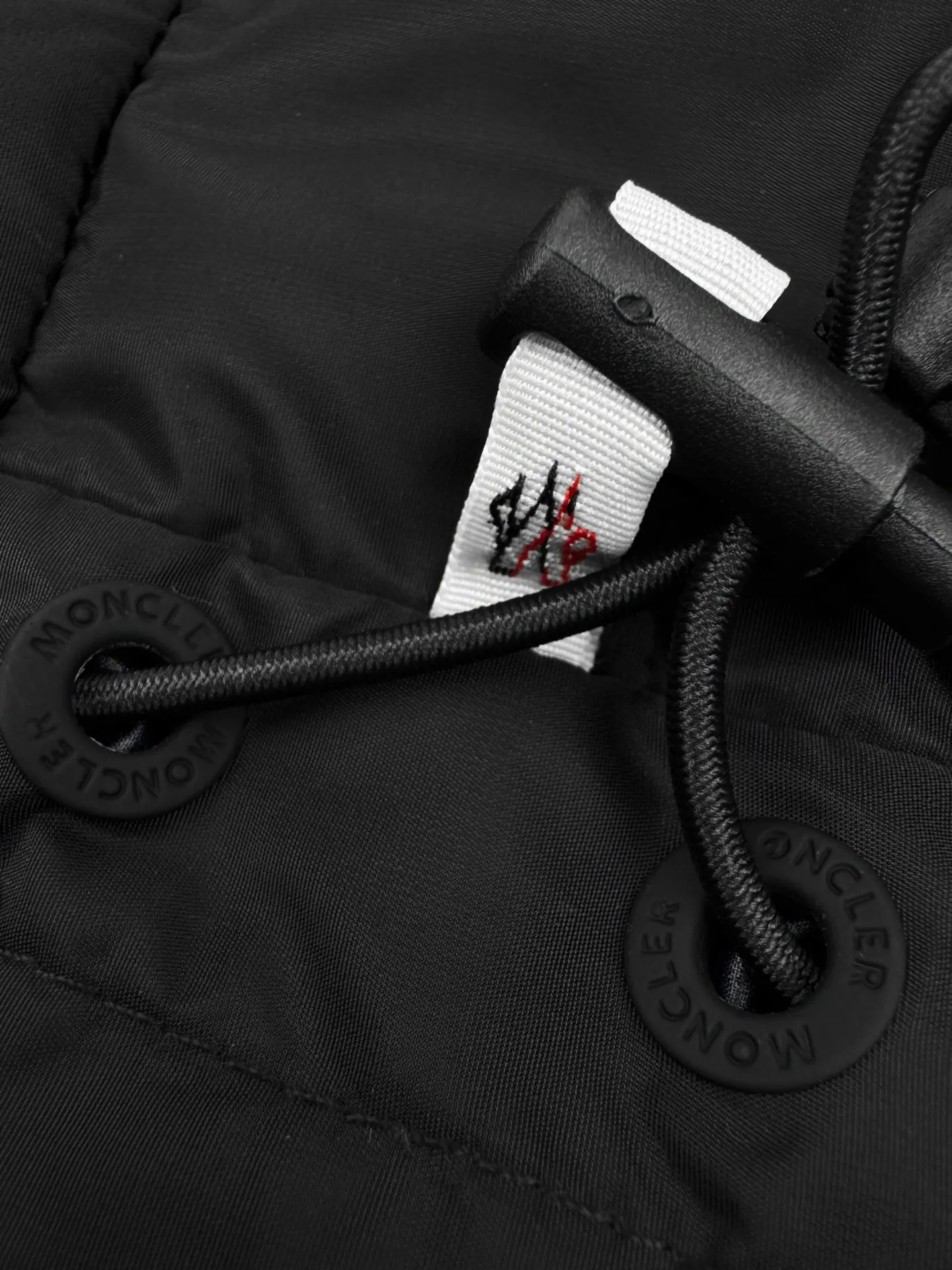 P780 Moncler logo woven splicing down jacket, custom matte lattice air shield down and 300D high-density calendered coating, using the new national standard 90 white duck down (welcome to test), full of down, full of warmth, light and fluffy, with a pure and extreme black tone, exuding an irresistible charm. The Monlcer triangle logo is embellished on the chest. The power aesthetics of the minimalist logo. The concentrated down filling in the front area creates dynamic insulation for the core heat dissipation zone of the human body. The hooded down is a moving warm flow barrier for the head and neck. It forms a thermal energy circulation system with the front panel. The elastic woven sleeves provide freedom of movement with a sense of compression, forming a relaxed and warm philosophy. The real high-end is to let function become the footnote of style. Process 1: Computer mechanical down filling. First, make the liner pattern to determine the filling area and determine the gram weight of down per square meter according to the original three-dimensional effect to calculate the amount of down filling for each piece. The computer down filling machine uses a digital weighing unit. Achieve stable measurement Process 2: 3D three-dimensional quilting technology. With the help of the programming system of the CNC quilting machine, the down in different areas is accurately separated to ensure that the filling is evenly fixed after sewing to avoid agglomeration or shifting. Process 3: Computer template machine line running process. The computer template machine line running process shows extremely high neatness and smoothness. The craftsman accurately controls the size during the operation to ensure that each row line meets the design requirements. The lines of the entire template are smooth and unified, clean and beautiful. Process 4: Triple locking and five-thread dense stitching process. Main seam locking + diagonal reinforcement + raw edge wrapping. Triple structure to form a three-dimensional protective net at the edge of the fabric to avoid stitch breakage. Paving materials: Customized 1:1 Moncler zipper. Customized 1:1 Moncler rope loop. Customized 1:1 Moncler logo. Customized 1:1 Moncler eyelet. Customized 1:1 Moncler trademark. Size: S M L XL Style number: 25378