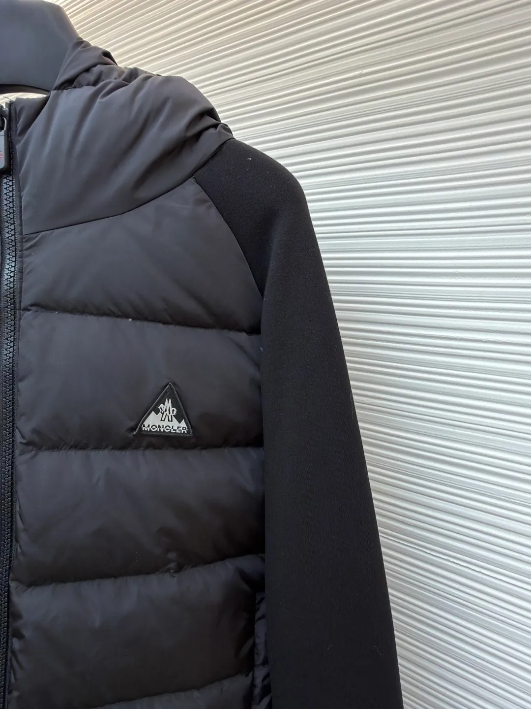 P810 Moncler logo woven splicing down jacket ●Item number: 1682129-C65 ●Material: white duck down fabric ●Technology: mechanical down filling ●Color: black ●Version: fitted version ●Weight: about 715 grams ●Size: S-M-L-XL ●Description: Customized matte lattice air shield down and 300D high-density calendered coating Use the new national standard 90 white duck down (welcome to test) Full flushing capacity Full of warmth, light and fluffy. With the dark green of the overlapping mountains as the background color, all things accumulate energy and create their own scenery in silence. The Monlcer triangle logo is embellished on the chest. The power aesthetics of the minimalist logo. The concentrated down filling in the front area creates dynamic insulation for the core heat dissipation zone of the human body. The hooded down is a moving warm flow barrier for the head and neck, forming a thermal energy circulation system with the front panel. The elastic woven sleeves provide freedom of movement with a sense of compression, forming a relaxed and warm philosophy, truly advanced. It is a mechanical down filling that allows function to become a footnote of style. Priority is given to making inner liner paper patterns to determine the down filling area and the gram weight of down per square meter according to the original three-dimensional effect, thereby calculating the filling amount of each cut piece. The computer down filling machine uses a digital weighing unit to achieve stable measurement. 3D three-dimensional quilting technology uses the programming system of the CNC quilting machine to accurately separate the down in different areas to ensure that the filling is evenly fixed after sewing. To avoid agglomeration or shifting, the template machine lines the lines. The line line process of the computer template machine shows extremely high neatness and smoothness. The craftsman accurately controls the size during the operation to ensure that each line meets the design requirements. The lines of the entire template are smooth and unified. Neat and beautiful, triple seam five-thread dense stitching process The triple structure of main seam overlocking + diagonal reinforcement + raw edge wrapping forms a three-dimensional protective net at the edge of the fabric to avoid stitch breakage. The overall wiring is straight and delicate, the fabric is comfortable and soft, and the color is consistent without color difference. It can be matched with the same style to create a fashionable look and control various occasions. Customized accessories, complete with three standards, same style for men and women!