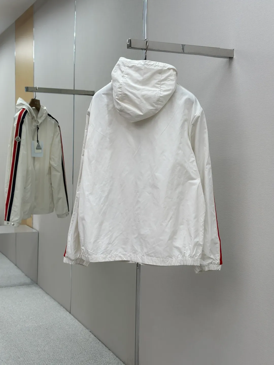 P560 MONCLER web-trimmed lightweight jacket Fabric selection: 100% polyester fiber is used to create a tough protective outer layer. It is known for its excellent tear resistance and wear resistance. It can quickly return to flatness during wearing and maintain the crisp and stylish appearance of the clothing for a long time. At the same time, it is not easy to deform after being washed for a long time.   Features: Two different colored decorative strips added to the center part of the sleeves. This design element can not only add visual highlights to clothing, making it more fashionable and unique. Craftsmanship: The webbing is precisely positioned along the cuffs to the seam of the collar and hat to ensure symmetry and overall smoothness. Before actual sewing, use very fine basting stitches for pre-fixing. This step is crucial to prevent the webbing from slipping, twisting, or wrinkling during sewing and ensuring that the final stitch is straight and perfect.  Accessories: Custom zipper puller, custom buttons with logo, custom hood drawstring elastic buckle SIZE: 1 2 3 4