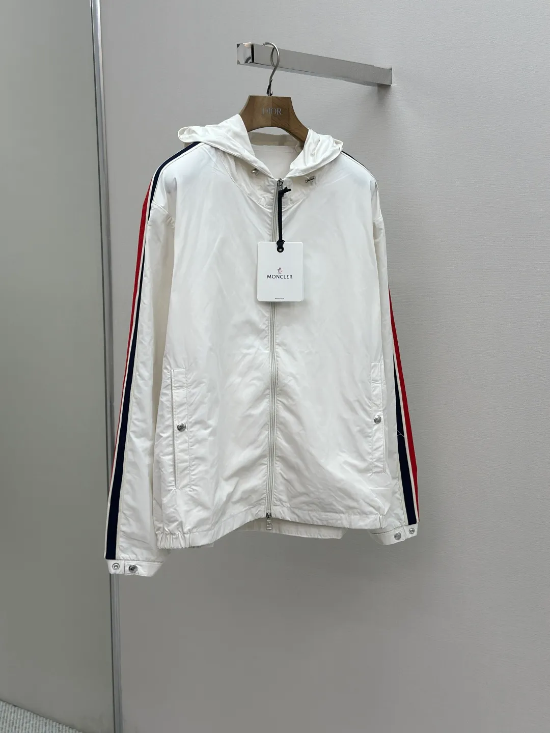 P560 MONCLER web-trimmed lightweight jacket Fabric selection: 100% polyester fiber is used to create a tough protective outer layer. It is known for its excellent tear resistance and wear resistance. It can quickly return to flatness during wearing and maintain the crisp and stylish appearance of the clothing for a long time. At the same time, it is not easy to deform after being washed for a long time.   Features: Two different colored decorative strips added to the center part of the sleeves. This design element can not only add visual highlights to clothing, making it more fashionable and unique. Craftsmanship: The webbing is precisely positioned along the cuffs to the seam of the collar and hat to ensure symmetry and overall smoothness. Before actual sewing, use very fine basting stitches for pre-fixing. This step is crucial to prevent the webbing from slipping, twisting, or wrinkling during sewing and ensuring that the final stitch is straight and perfect.  Accessories: Custom zipper puller, custom buttons with logo, custom hood drawstring elastic buckle SIZE: 1 2 3 4