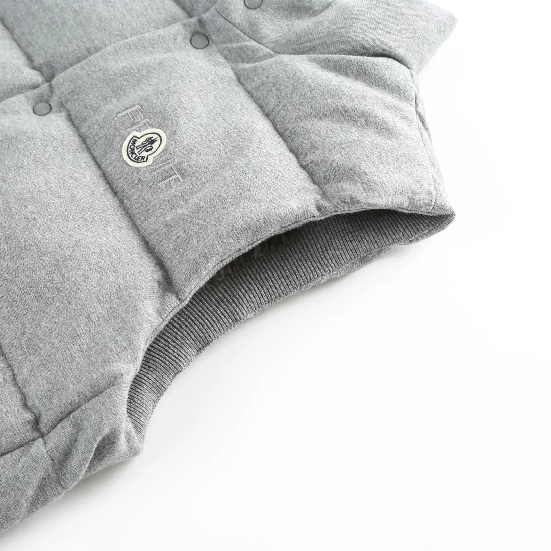 P760 MONCLER cotton embroidered down vest Fabric selection: Lightweight knitted fabric made of 100% cotton fiber. The fiber characteristics are soft to the touch. The knitted structure gives the fabric a certain degree of elasticity in the horizontal and vertical directions. Even though it is a down vest, it can move freely without any sense of restraint. The air circulates freely between the coils and has good breathability. It is not easy to accumulate moisture inside, improving the wearing experience. Lining fabric: The high-density lining is woven with ultra-fine nylon denier, with a thickness of 0.08mm to avoid increasing the overall weight and making it smooth to wear. The high-density woven structure forms a wind resistance layer to protect the thermal efficiency of the thermal layer from loss. It can also withstand the expansion pressure of down and prevent deformation and damage after long-term use.  Process: The high-precision computing system of the computerized embroidery machine controls the coordinated operation of the machine head, needle bar, and bobbin. The fabric frame moves accurately in the horizontal and vertical directions to form a stitch track. The upper and lower thread tensions are adjusted to ensure that the stitches are smooth and free of floating threads. The chest, lower front and lower back panels are decorated with three different letter embroideries. The finished product has clear patterns and no burrs on the edges.  90 national standard high-quality white duck down: Selected high-fill down, with a fill power of 650fp, light and warm, with excellent temperature locking performance and good resilience.  Accessories: One-to-one customized badges, One-to-one customized snaps, One-to-one customized three-label, One-to-one customized zipper pullers SIZE: S M L XL