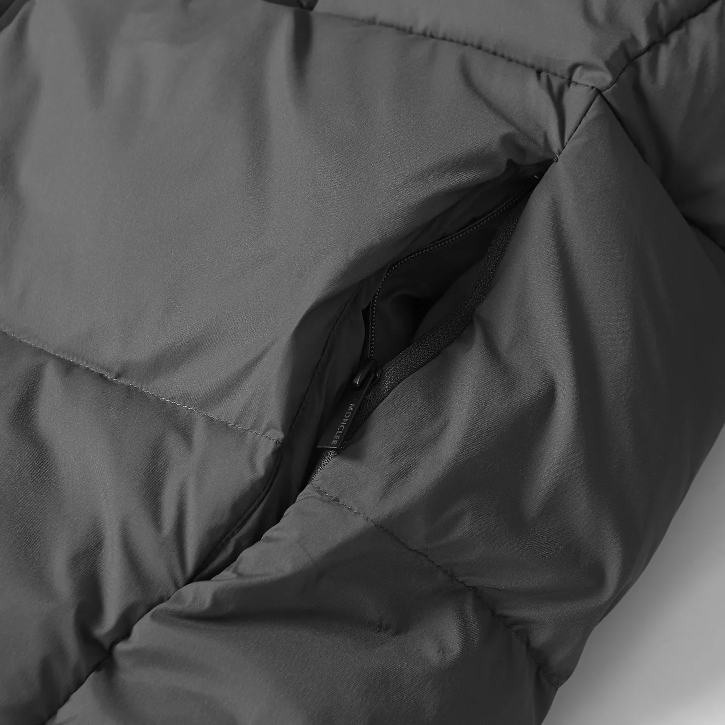 The design of the P860 Moncler Fusain short down jacket is inspired by the thrilling racing sports, echoing the three-dimensional tailoring and dynamic structure of the racing driver's uniform. Diamond quilting is used to build a thermal barrier, and the lightweight fabric is full of fluffy warmth. The silhouette is neat and not bulky, and the hooded design adds casualness. It is made of quilted nylon fabric, which has excellent warmth and protection. It is not only a textured armor to resist the cold wind when commuting, but also a fashion tool to create a minimalist and high-end feel when going out. In the cold winter, you can achieve the dual elegance of temperature and style with a piece of down. The short design features reflective zippers for a modern look. Code number: 12345 Color: black, gray