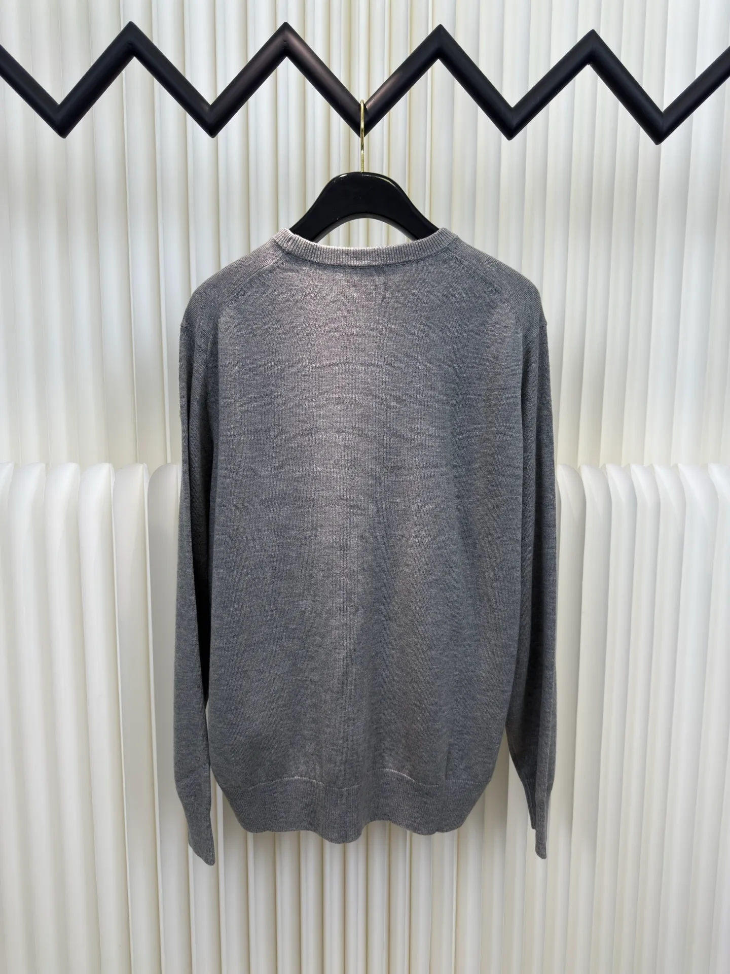 P440 MONCLER jacquard crew neck sweater is made of wool blended fabric, mainly 95% wool, combined with 4% nylon and 1% spandex. The main body of wool ensures the warmth and comfort of the clothing. The addition of a small amount of nylon and spandex significantly improves the elasticity and wear resistance. The ribbed decorative parts are made of 100% wool, which further enhances the overall texture.  Through the high needle count and fine gauge loom, combined with the orderly direction of the internal yarn, the floating threads are cleverly woven and stored, with almost no unnecessary thread mess. The color switching of each group of letters is synchronized with the knitting needles in milliseconds, forming a delicate letter LOGO jacquard decoration on the chest. Size S M L XL