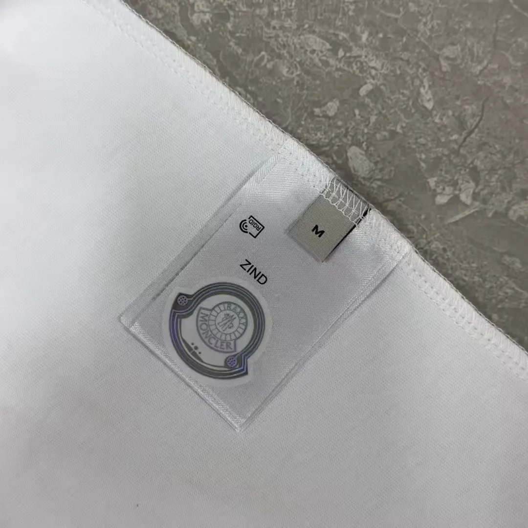 P140 Upgraded version "Mobile phone smart sensor ~ NFC chip armband ~ Direct access to the official website for anti-counterfeiting" "Moncler ~ Mouth Mouth" 2025 new high-quality round neck short-sleeved T-shirt. The cuffs have imported embroidered labels. Customized dyeing, very comfortable to touch. Super versatile and good-looking short-sleeved. Complete with three labels. Non-market ordinary version. Feel free to compare. Quality is absolutely guaranteed! ‼ First of all, this original fabric is all custom-woven with 32-count double yarn fabric, 250G, and the weight is the same‼ Fine workmanship, double waistcoat method, double waistcoat method, double waistcoat method makes the whole dress more three-dimensional, which is not a craft that ordinary T-shirts can achieve🤪 Size: S-M-L-XL-2XL Color: black, white, apricot, same style for men and women