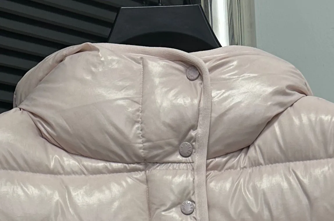 P860 [Moncler] Hooded, waisted women's short down jacket. The barante down jacket is made of glossy nylon fabric and is inspired by the 1970s. It adopts a waist design and presents an A-line silhouette, highlighting a feminine style. An adjustable hood and signature logo patch add finishing touches. Details · Made of lon laqué fabric · lon laqué lining · Filled with down · Adjustable hood · Zipper and snap closure · Suit pocket · Adjustable cuffs Size: 0/1/2/3